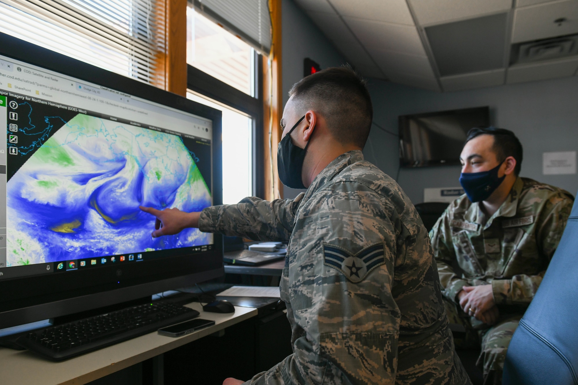 Senior Airman Jonah Reeves, 22nd Operations Support Squadron weather forecaster, discuses water vapor bands March 3, 2021, at McConnell Air Force Base, Kansas. The system is effectively utilized for identifying large scale patterns in the upper troposphere, jet streams and regions where the potential for turbulence exists. (U.S. Air Force photo by Senior Airman Nilsa Garcia)