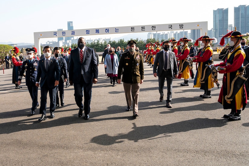 American and South Korean leaders walk together during a welcoming ceremony.