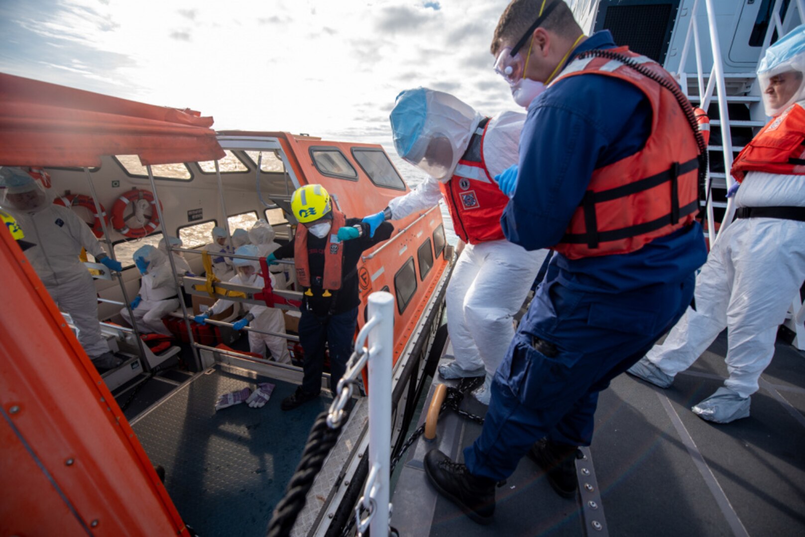 A Coast Guard Cutter Tern crew member assists a healthcare official onto a Grand Princess lifeboat off the coast of San Francisco, California, March 9, 2020. The Tern assisted in the transportation of medical officials to the Grand Princess. (U.S. Coast Guard photo by Petty Officer 3rd Class Taylor Bacon)