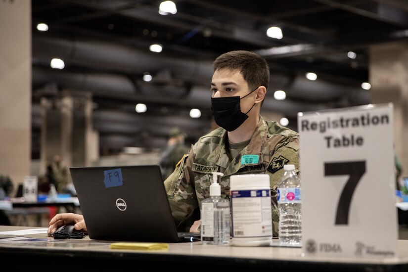 Spc. Mykhaylo Tatarskyy, a native of Philadelphia, Pennsylvania, with the Pennsylvania National Guard, registers a community member for a COVID-19 vaccine at the state-run, federally-supported Center City Community Vaccination Center in the Pennsylvania Convention Center in Philadelphia on March 17, 2021.