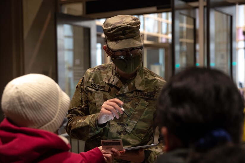 Spc. Grant Wagner, a native of Marysville, Pennsylvania, with the Pennsylvania National Guard, registers a community member for a COVID-19 vaccine at the state-run, federally-supported Center City Community Vaccination Center in the Pennsylvania Convention Center in Philadelphia on March 17, 2021.