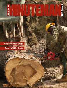 This is the cover photo for the 1st Volume of the 2021 Minuteman. Pictured is an Airman operating a chainsaw, cutting a large tree.