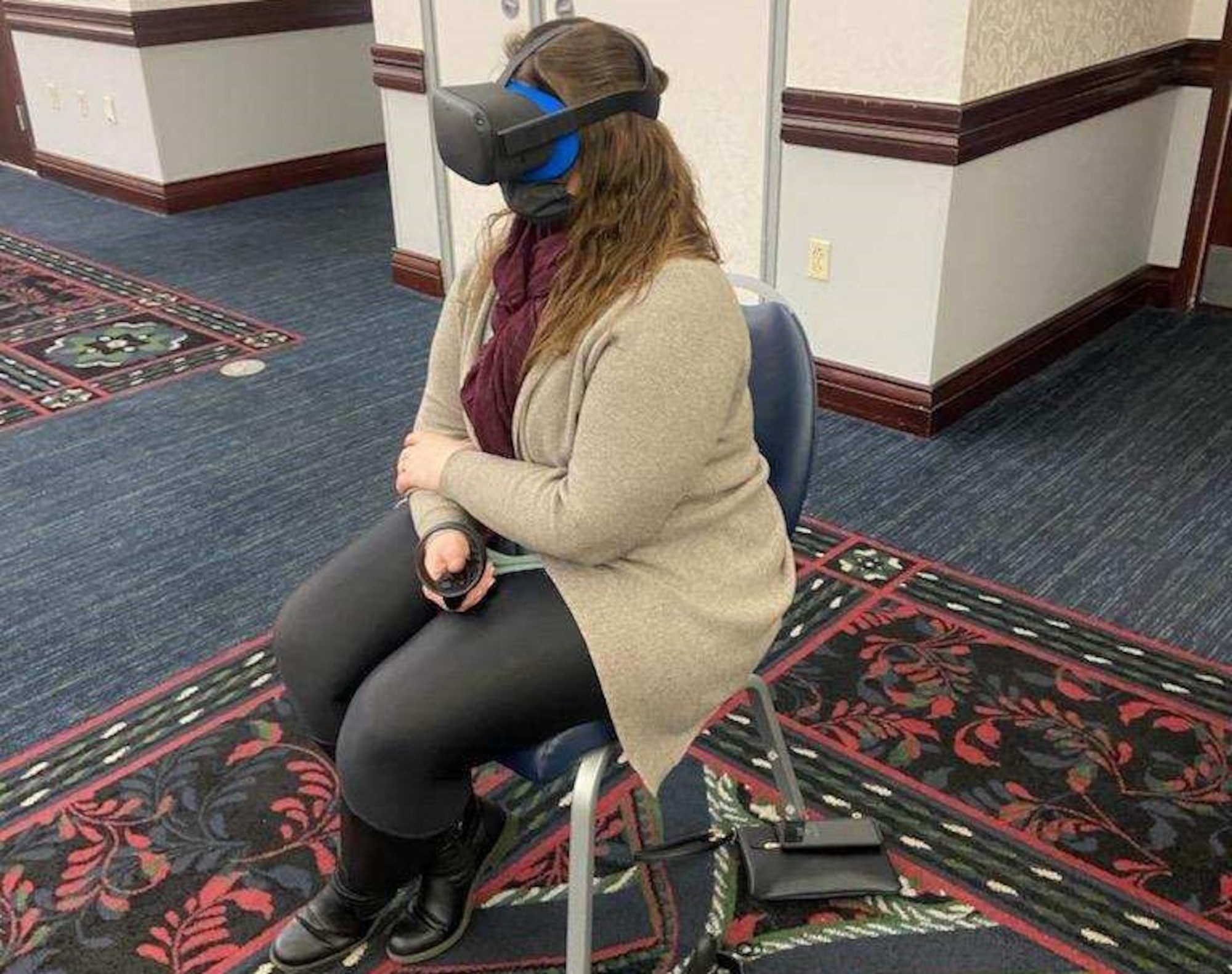 Contract specialist experiences virtual reality suicide prevention training with VR goggles and a controller.