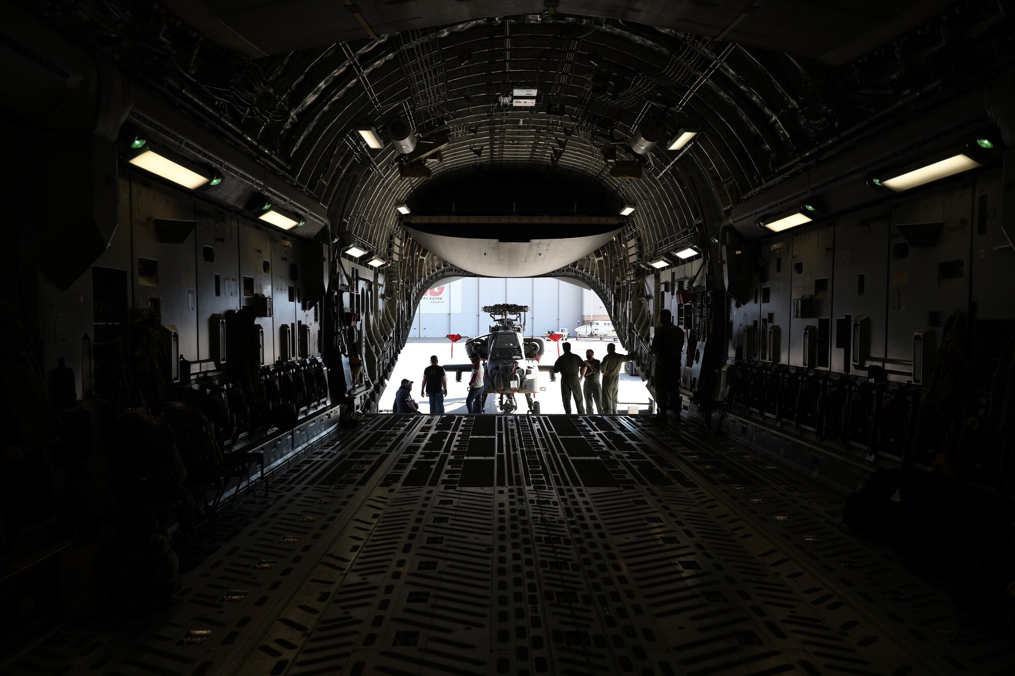Members of the Arizona National Guard’s 161st Air Refueling Wing, the Royal Air Force, and The Boeing Company load an AH-64 Apache helicopter into a Royal Air Force C-17 Globemaster III, at the Goldwater Air National Guard Base in Phoenix, Arizona Jan. 21, 2021. The 161st was contacted by the U.S. Army’s Apache foreign military sales program office to help load the attack helicopters on C-17 aircraft for shipment to the UK, due to its secure ramp space for the project, and qualified air transportation specialists who can process complex air cargo ensuring safety of flight during air transport.  (U.S. Army National Guard photo by Spc. Thurman Snyder)
