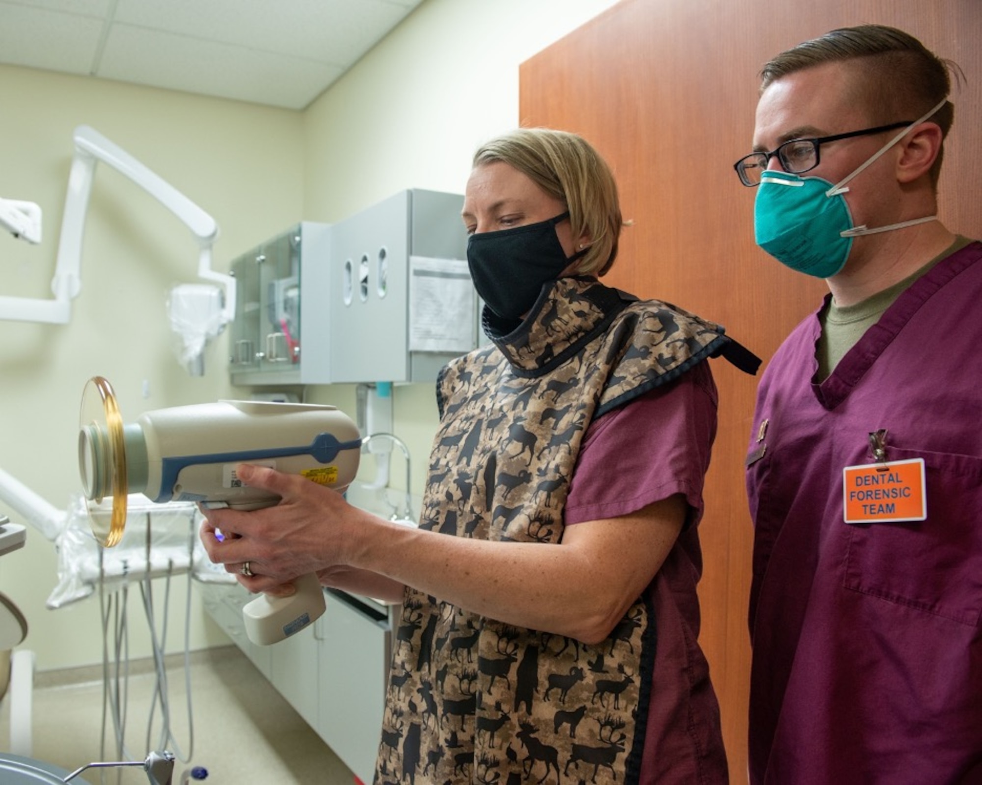 U.S. Air Force Capt. Ryan Zarnowski, right, a general dentist assigned to the 673d Dental Squadron, teaches U.S. Air Force Col. Kirsten Aguilar, Joint Base Elmendorf-Richardson and 673d Air Base Wing commander, how to operate an X-ray unit at JBER, Alaska, March 2, 2021.