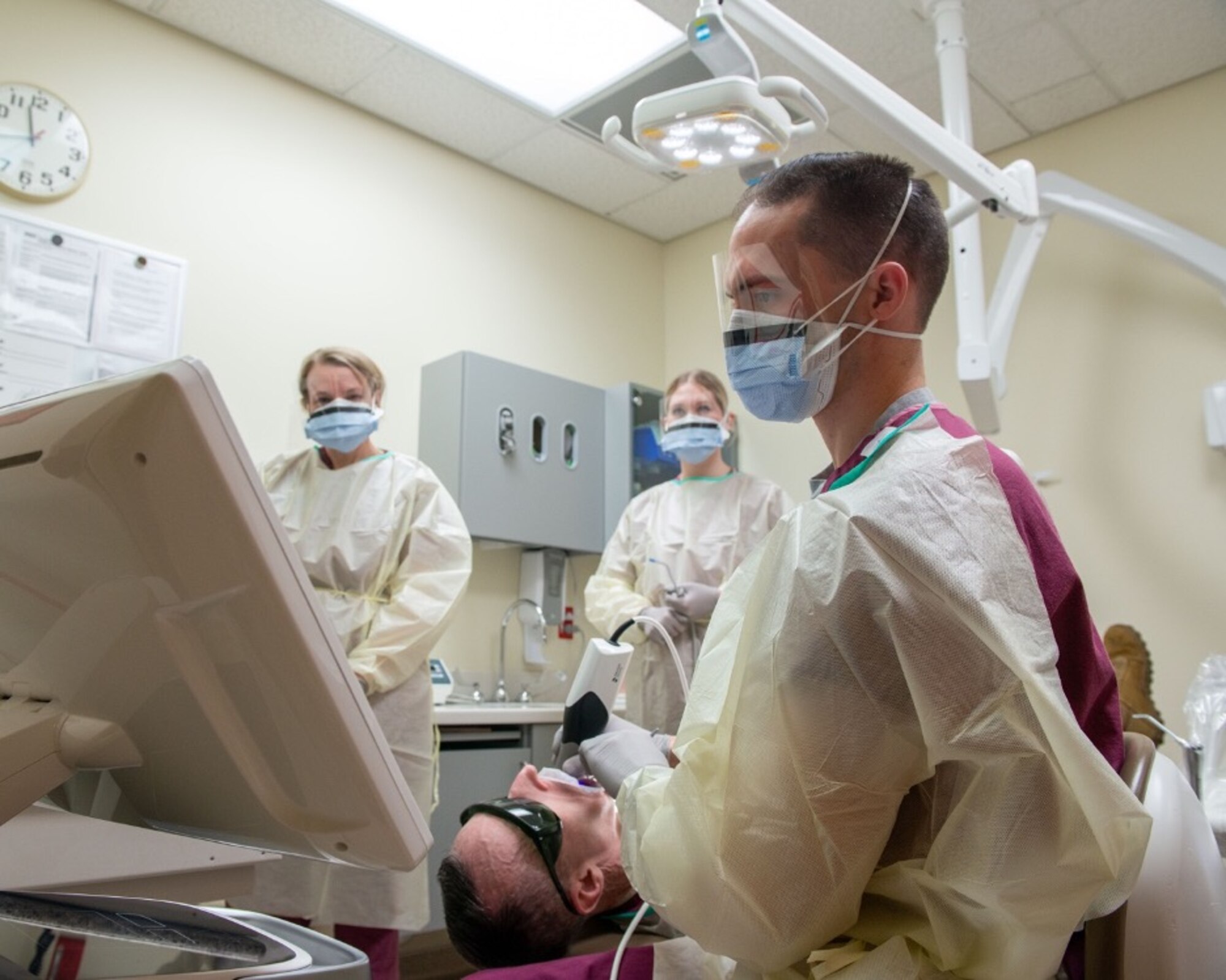 U.S. Air Force Senior Airman Regan Bassett, front, a dental technician assigned to the 673d Dental Squadron, performs a dental scan on U.S. Air Force Chief Master Sgt. Lee Mills, Joint Base Elmendorf-Richardson and 673d Air Base Wing command chief, during a 673d Dental Squadron immersion tour at Joint Base Elmendorf-Richardson, Alaska, March 2, 2021.