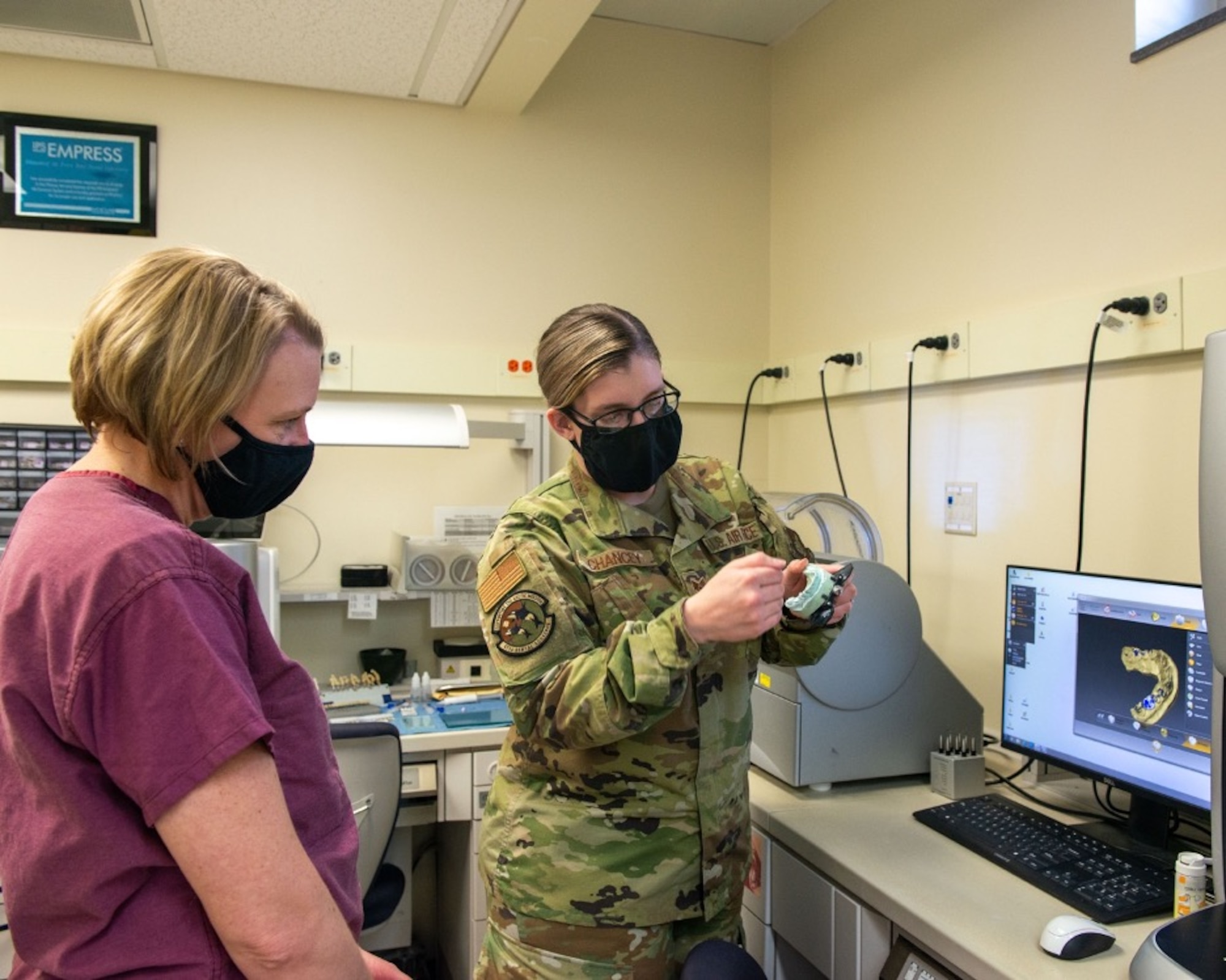 U.S. Air Force Staff Sgt. Aimee Chancey, right, a dental laboratory technician assigned to the 673d Dental Squadron, shows a model camera for crowns and implants to U.S. Air Force Col. Kirsten Aguilar, Joint Base Elmendorf-Richardson and 673d Air Base Wing commander, at JBER, Alaska, March 2, 2021.
