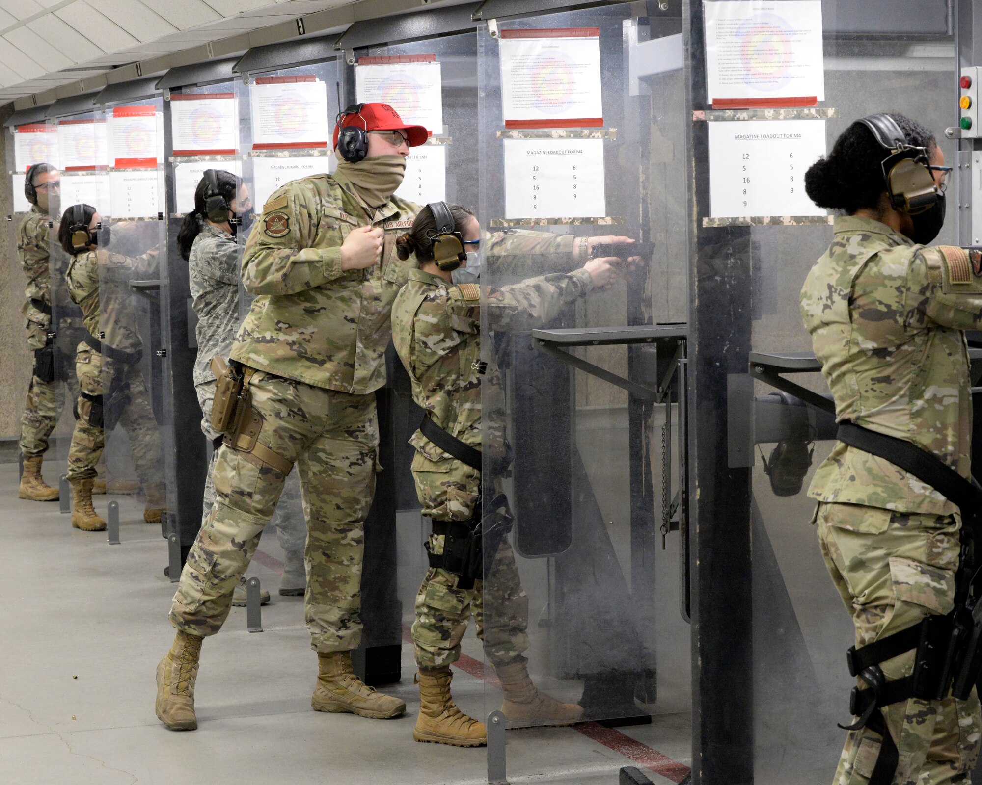 Air Force Senior Airman Clayton Nyp, an 88th Security Forces Squadron combat arms instructor, works with 2nd Lt. Mariah Armstrong, an 88th Medical Group critical care nurse, as she qualifies with the M9 pistol inside the 88th Security Forces Squadron Combat Arms firing range at Wright-Patterson Air Force Base, Ohio on Feb. 18, 2021. Weapons qualification is part of the readiness standards for the 88th Air Base Wing. (U.S. Air Force photo by Ty Greenlees)