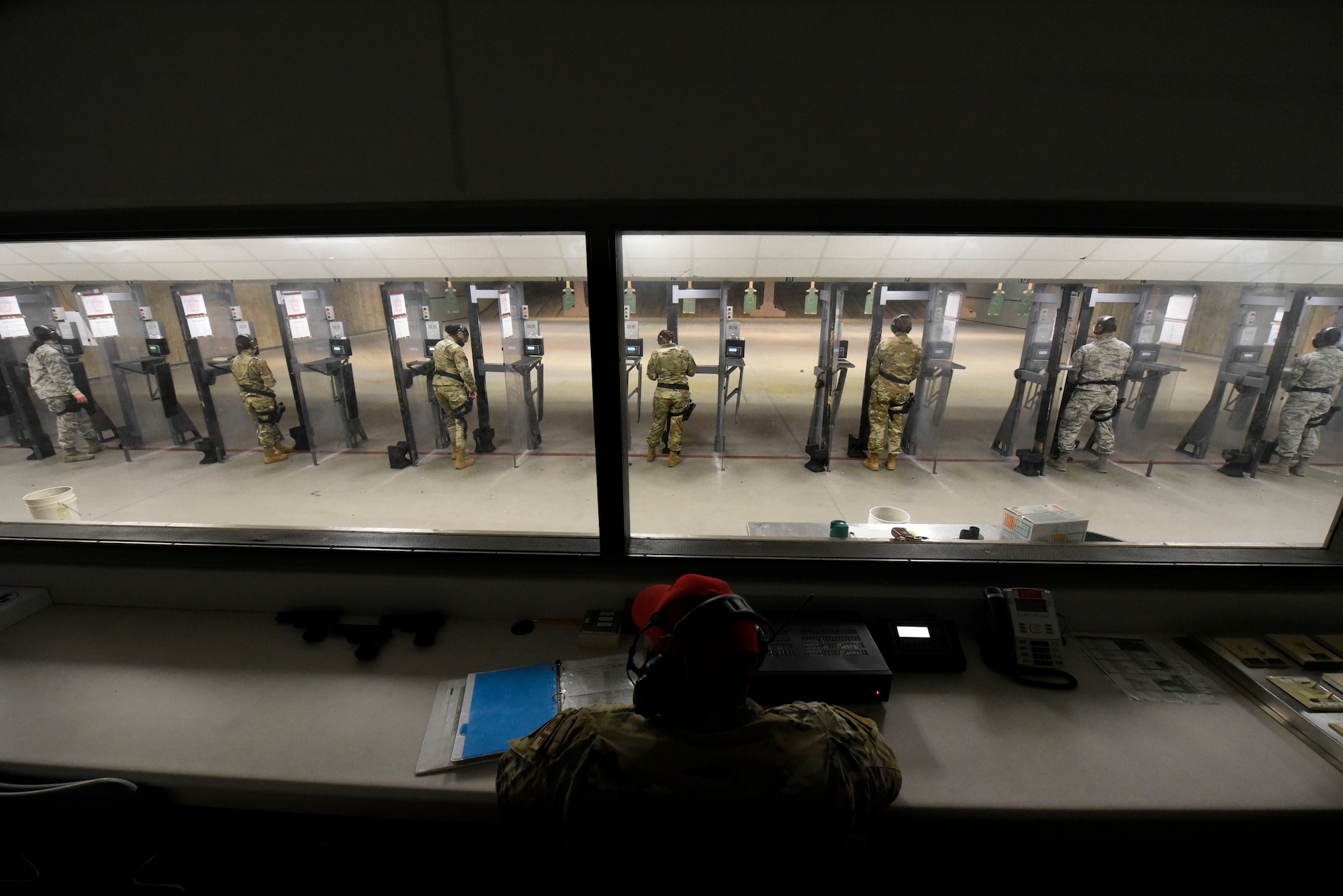 Personnel with the 88th Medical Group step to the firing line under watchful eyes of Combat Arms instructors inside the 88th Security Forces Squadron Combat Arms firing range at Wright-Patterson Air Force Base, Ohio on Feb. 18, 2021. The Airmen were qualifying with the M9 pistol as part of the readiness standards for the 88th Air Base Wing. (U.S. Air Force photo by Ty Greenlees)