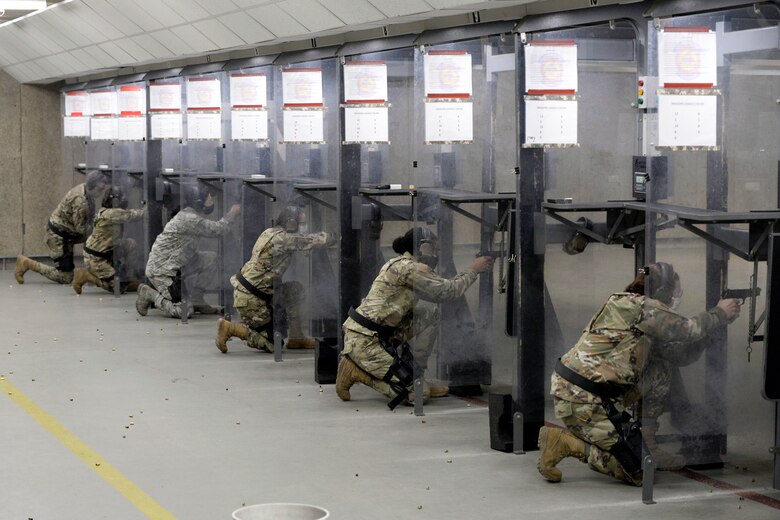 Personnel with the 88th Medical Group shoot from the kneeling position inside the 88th Security Forces Squadron Combat Arms firing range at Wright-Patterson Air Force Base, Ohio on Feb. 18, 2021. The Airmen were qualifying with the M9 pistol. Weapons qualification is part of the readiness standards for the 88th Air Base Wing. (U.S. Air Force photo by Ty Greenlees)