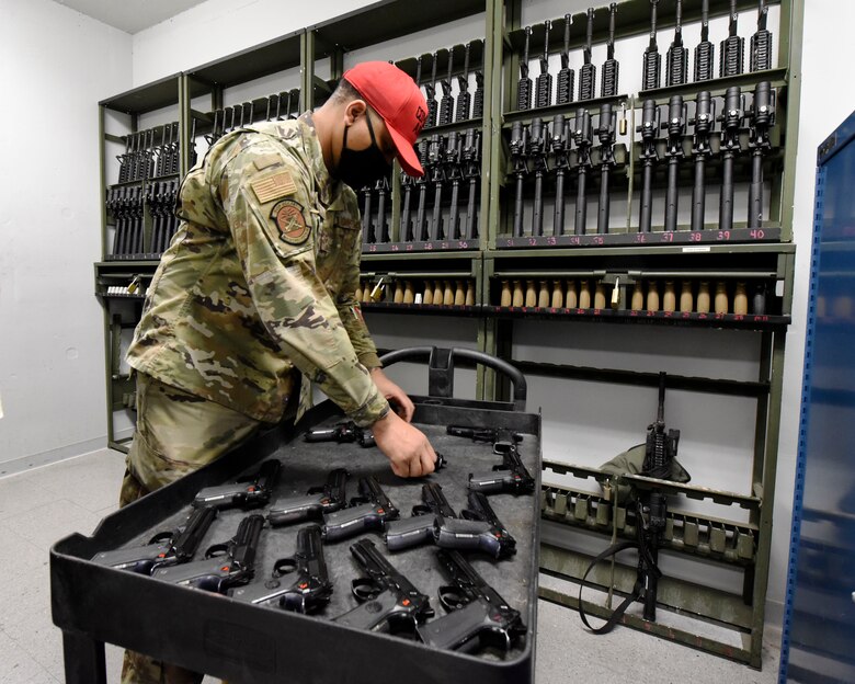 Air Force Senior Airman Jerome Fogg, a combat arms instructor with the 88th Security Forces Squadron, prepares M9 pistols for a pistol qualification course at Wright-Patterson Air Force Base, Oho on Feb. 18, 2021. Weapons qualification is part of the readiness standards for the 88th Air Base Wing. (U.S. Air Force photo by Ty Greenlees)