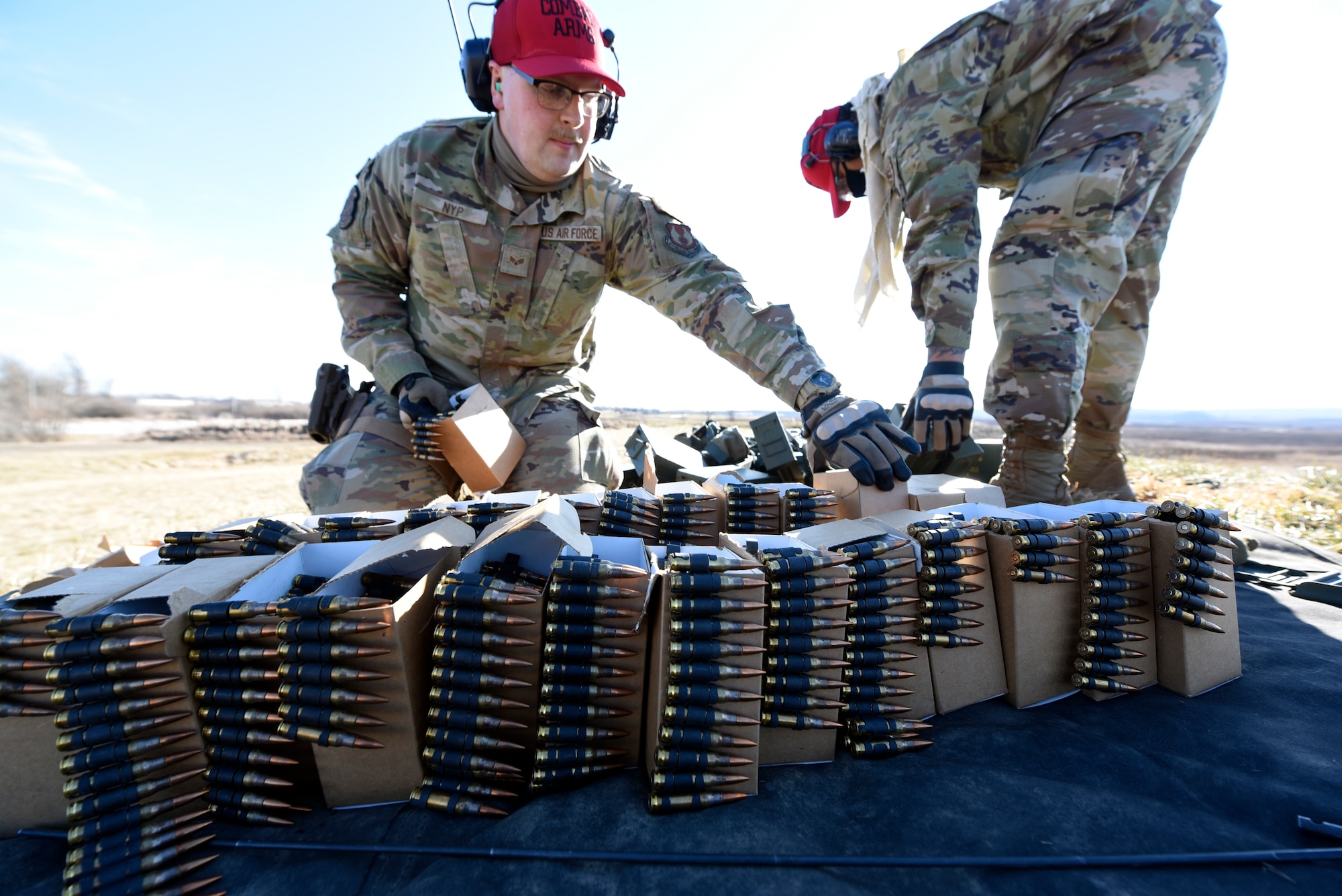 Air Force Senior Airmen Clayton Nyp, left, and Jerome Fogg, both 88th Security Forces Squadron combat arms instructors, prepare ammunition belts for an M240B machine gun at Camp Atterbury in Edinburgh, Indiana, on Feb. 25, 2021. The 88th SFS combat arms instructors, from Wright-Patterson Air Force Base, Ohio, travel to Camp Atterbury multiple times each year for readiness and qualification training with deployers on machine guns and grenade launchers. (U.S. Air Force photo by Ty Greenlees)