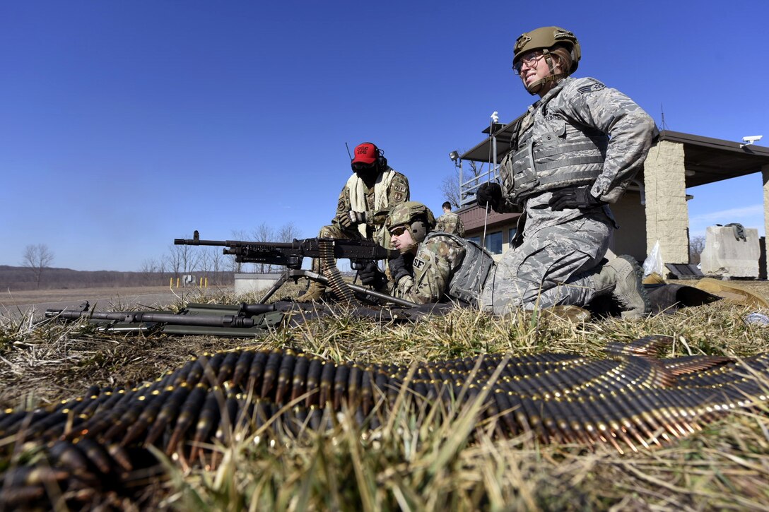 Air Force Airman 1st Class Michael Lawhead, center, an 88th Security Forces Squadron alarm monitor, fires an M240 machine gun with Senior Airman Aurielle Marvin, an 88th SFS patrolman, under the direction of Senior Airman Jerome Fogg, an 88th SFS combat arms instructor, left, at Camp Atterbury in Edinburgh, Indiana, on Feb. 25, 2021. The combat arms instructors, from Wright-Patterson Air Force Base, Ohio, travel to Camp Atterbury multiple times each year for readiness and qualification training with deployers on machine guns and grenade launchers. (U.S. Air Force photo by Ty Greenlees)