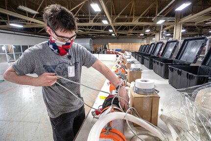Gabe Morton, a work study employees with Shop 11, assembles Biocontainment System kits May 13, 2020, for use aboard U.S. Naval ships, that are being assembled in the Building 460 Sail Loft at Puget Sound Naval Shipyard & Intermediate Maintenance Facility in Bremerton, Washington.