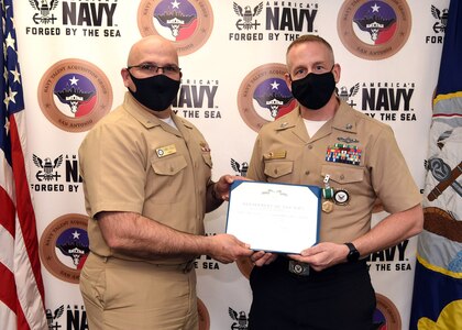 Petty Officer 1st Class Ryan Evans (right), a medical officer programs recruiter assigned to Talent Acquisition Onboarding Center Capital City, was awarded the Navy and Marine Corps Commendation Medal March 9 by Rear Adm. Dennis Velez, commander, Navy Recruiting Command at Navy Talent Acquisition Group San Antonio headquarters.  Evans earned the award for being NRC’s Medical Officer Recruiter of the Year for Fiscal Year 2020.