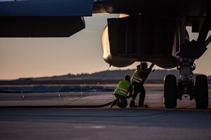 Two crew chiefs assigned to the 9th Expeditionary Bomb Squadron conduct a hot-pit refueling of a B-1B Lancer at Ørland Air Force Station, Norway, March 14, 2021. Hot-pit refuelings allow bombers to be refueled after landing at any airfield capable of supporting the aircraft. (U.S. Air Force photo by Airman 1st Class Colin Hollowell)