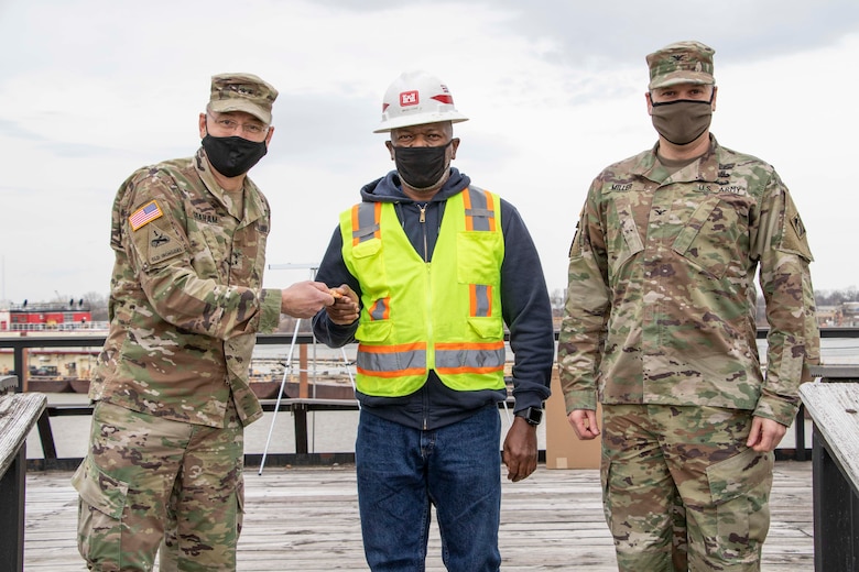 IN THE PHOTOS, The U.S. Army Corps of Engineers Deputy Commanding General for Civil and Emergency Operations, Maj. Gen. William (Butch) Graham and the Senior Official Performing the Duties of the Assistant Secretary of Army (Civil Works), Vance Stewart, visited the Memphis District last week. While there, they had the opportunity to welcome home and congratulate the Revetment Team after completing one of the district's longest seasons in history. Here, a representative of the Revetment Team is presented a coin for a job well done. (USACE photos by Vance Harris)