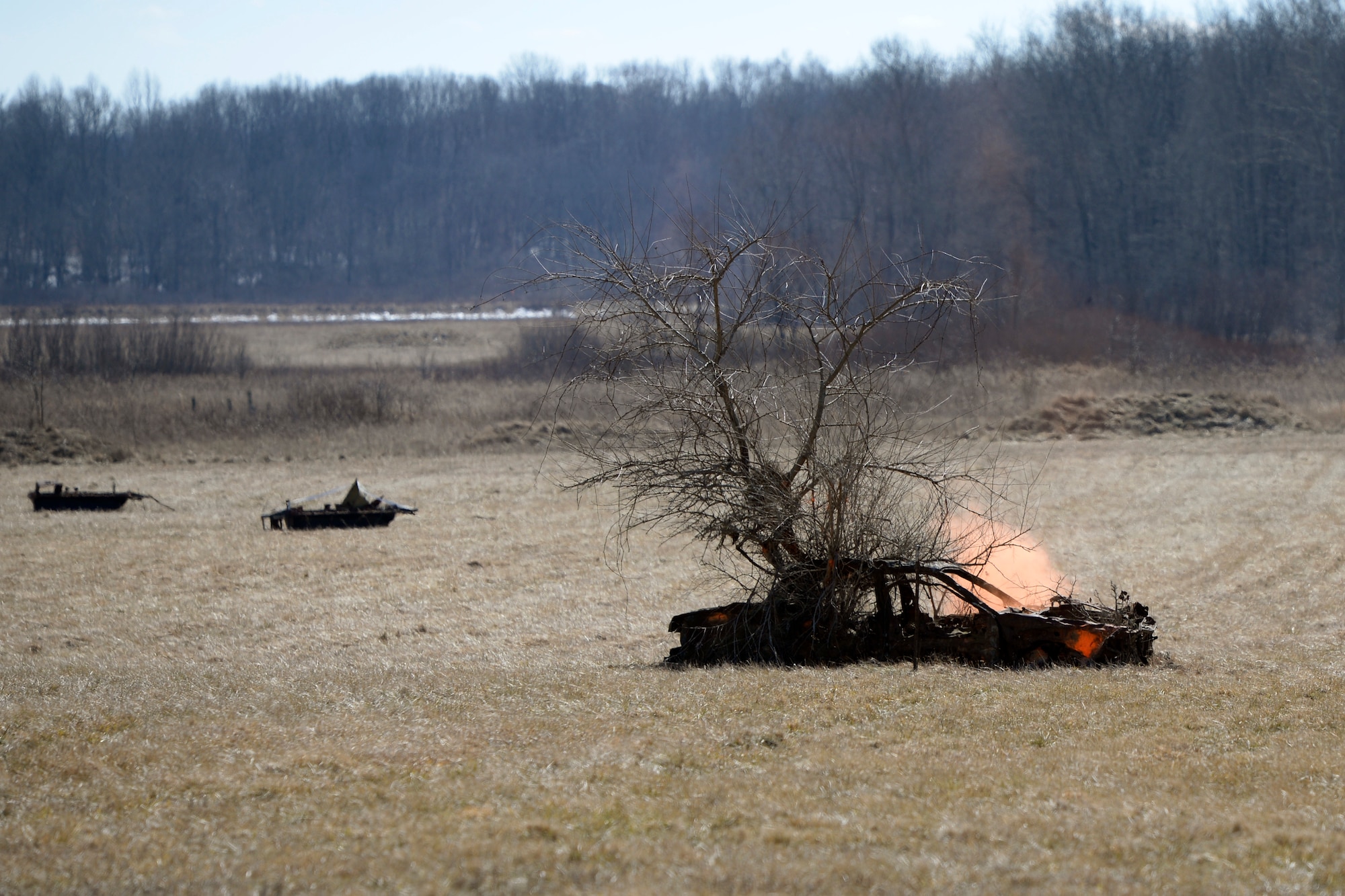 A 40mm practice grenade, known as Cheeto rounds, shot by Air Force Technical Sgt. Richard Thomas, the 88th Security Forces Squadron noncommissioned officer in charge of Combat Arms, releases a puff of orange smoke upon impact at Camp Atterbury in Edinburgh, Indiana, on Feb. 25, 2021. The combat arms instructors, from Wright-Patterson Air Force Base, Ohio, travel to Camp Atterbury multiple times each year for readiness and qualification training with deployers on machine guns and grenade launchers. (U.S. Air Force photo by Ty Greenlees)