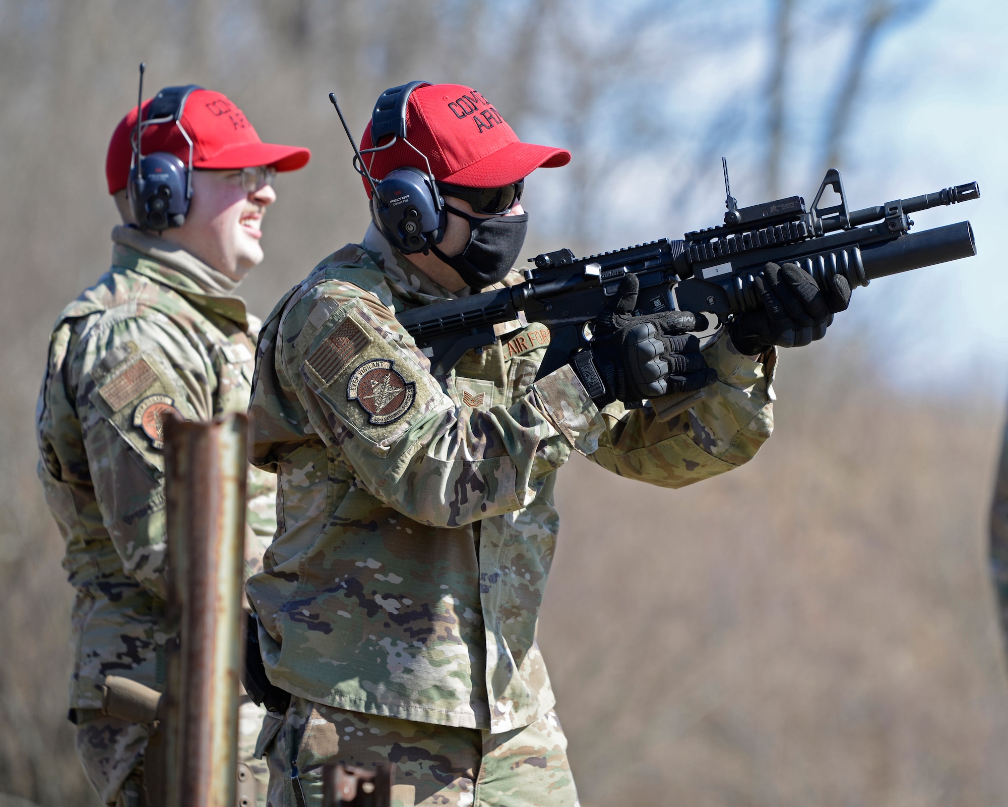 Air Force Technical Sgt. Richard Thomas, the 88th Security Forces Squadron noncommissioned officer in charge of Combat Arms, right, fires an M203 grenade launcher at Camp Atterbury in Edinburgh, Indiana, on Feb. 25, 2021. The combat arms instructors, from Wright-Patterson Air Force Base, Ohio, travel to Camp Atterbury multiple times each year for readiness and qualification training with deployers on machine guns and grenade launchers. (U.S. Air Force photo by Ty Greenlees)