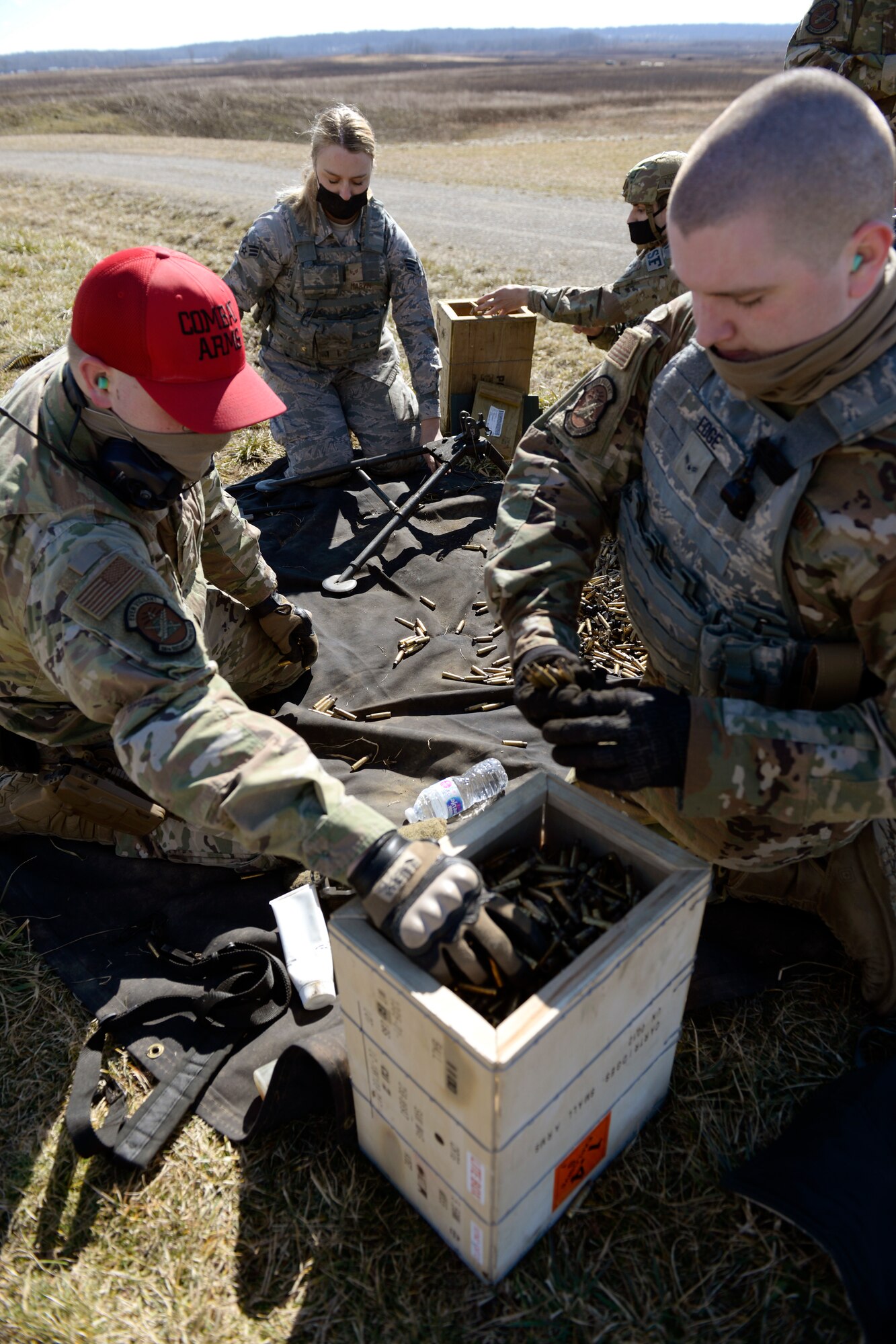Air Force 88th Security Forces Squadron defenders retrieve bullet casings and machine gun belt clips from an M240B machine gun at Camp Atterbury in Edinburgh, Indiana, on Feb. 25, 2021. Members of the 88th SFS, travel to Camp Atterbury multiple times each year for readiness and qualification training with deployers on machine guns and grenade launchers. (U.S. Air Force photo by Ty Greenlees)