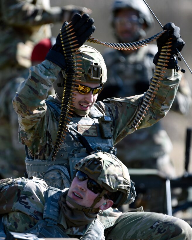 Air Force Airman 1st Class Michael Lawhead, an 88th Security Forces Squadron alarm monitor, prepares to load an M240B machine gun with Staff Sgt. Sawyer McIntyre, an 88th SFS combat arms instructor, at Camp Atterbury in Edinburgh, Indiana, on Feb. 25, 2021. The combat arms instructors, from Wright-Patterson Air Force Base, Ohio, travel to Camp Atterbury multiple times each year for readiness and qualification training with deployers on machine guns and grenade launchers. (U.S. Air Force photo by Ty Greenlees)