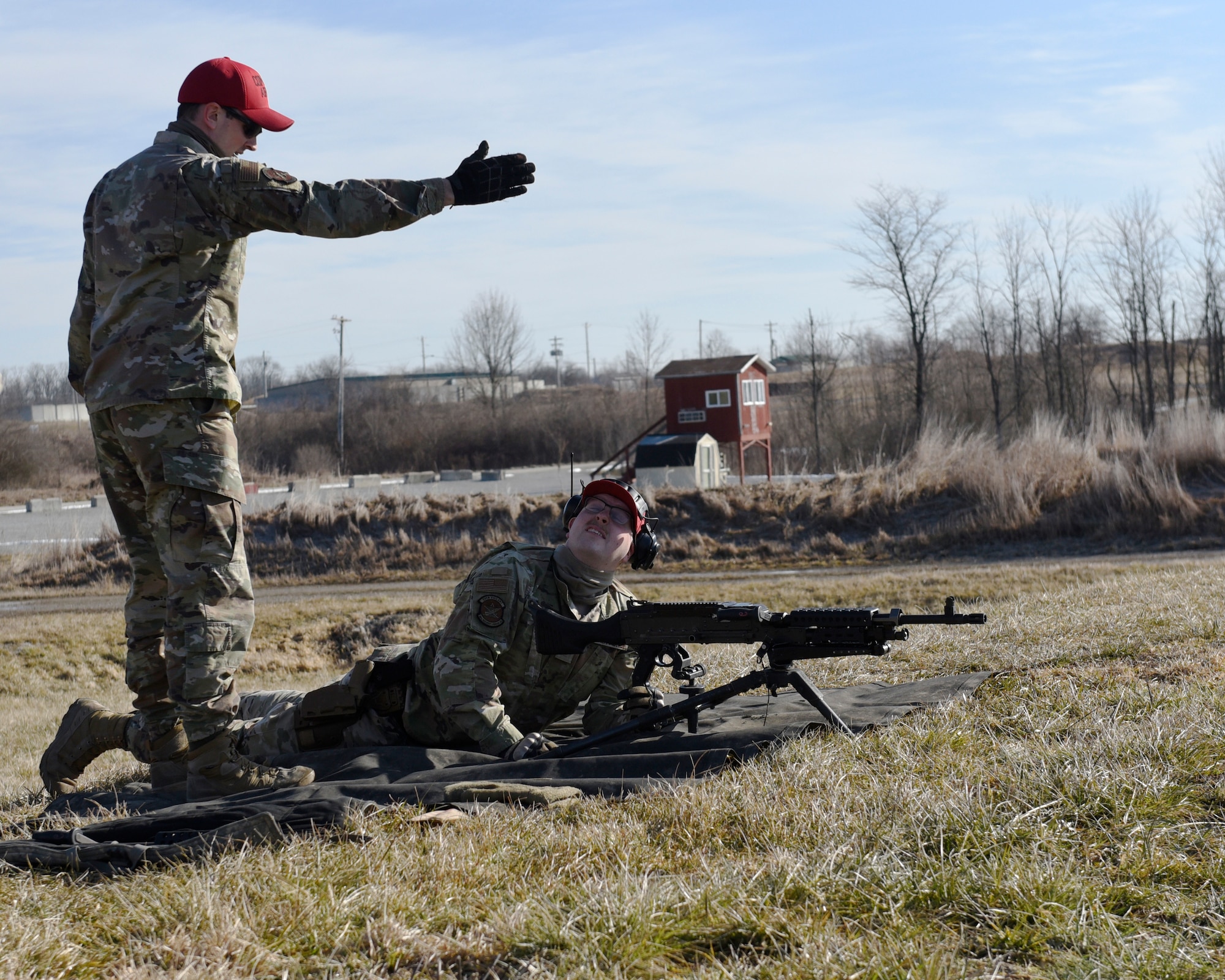 Air Force Staff Sgt. Sawyer McIntyre, left, an 88th Security Forces Squadron combat arms instructor, talks with Senior Airman Clayton Nyp, an 88th SFS combat arms instructor, who is sighting an M240B machine gun at Camp Atterbury in Edinburgh, Indiana, on Feb. 25, 2021. The 88th SFS combat arms instructors, from Wright-Patterson Air Force Base, Ohio, travel to Camp Atterbury multiple times each year for readiness and qualification training with deployers on machine guns and grenade launchers. (U.S. Air Force photo by Ty Greenlees)