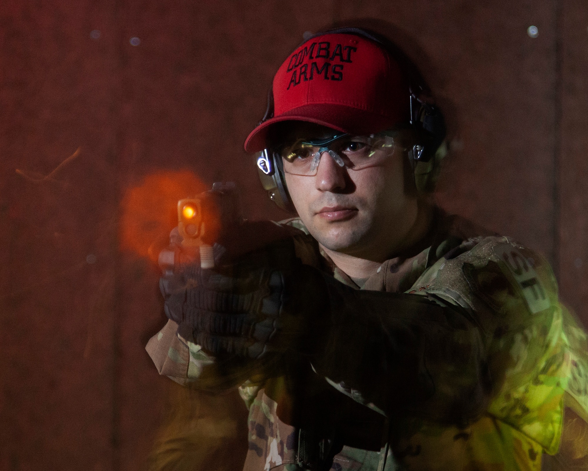 Air Force Technical Sgt. Richard Thomas, the 88 Security Forces Squadron noncommissioned officer in charge of Combat Arms, is captured firing the M18 pistol with a remote camera on the indoor range at Wright-Patterson Air Force Base, Ohio, on Feb. 17, 2021. Thomas and his team of combat arms trainers work to keep personnel in the 88th Air Base Wing weapons qualified for readiness and deployment requirements. (U.S. Air Force photo by Ty Greenlees)