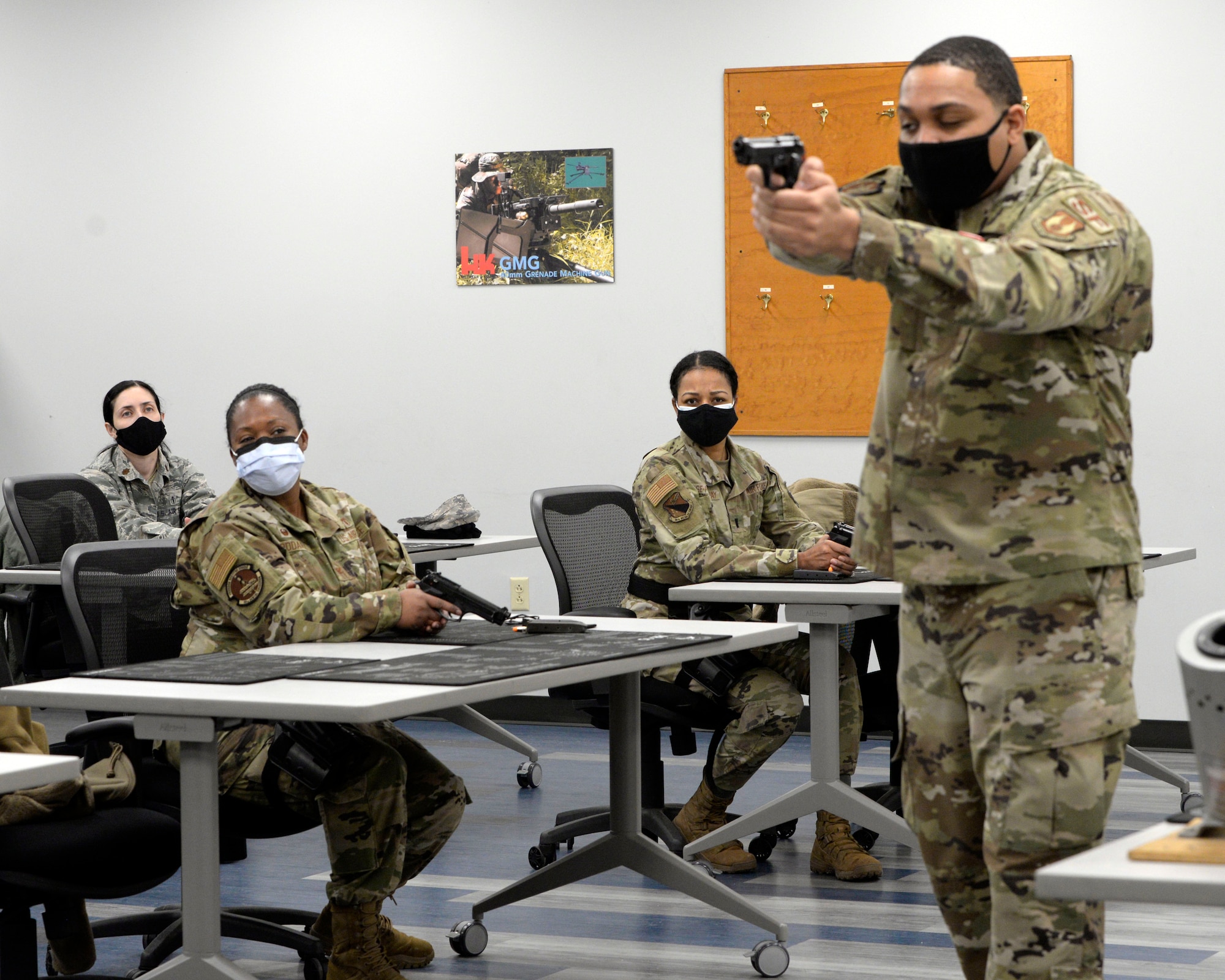 Air Force Senior Airman Jerome Fogg, an 88th Security Forces Squadron combat arms instructor, teaches sighting and posture for the M9 pistol during a qualification course at Wright-Patterson Air Force Base, Ohio on Feb. 18, 2021. Weapons qualification is part of the readiness standards for the 88th Air Base Wing. No live ammunition is allowed in the classroom portion of the qualification course. (U.S. Air Force photo by Ty Greenlees)