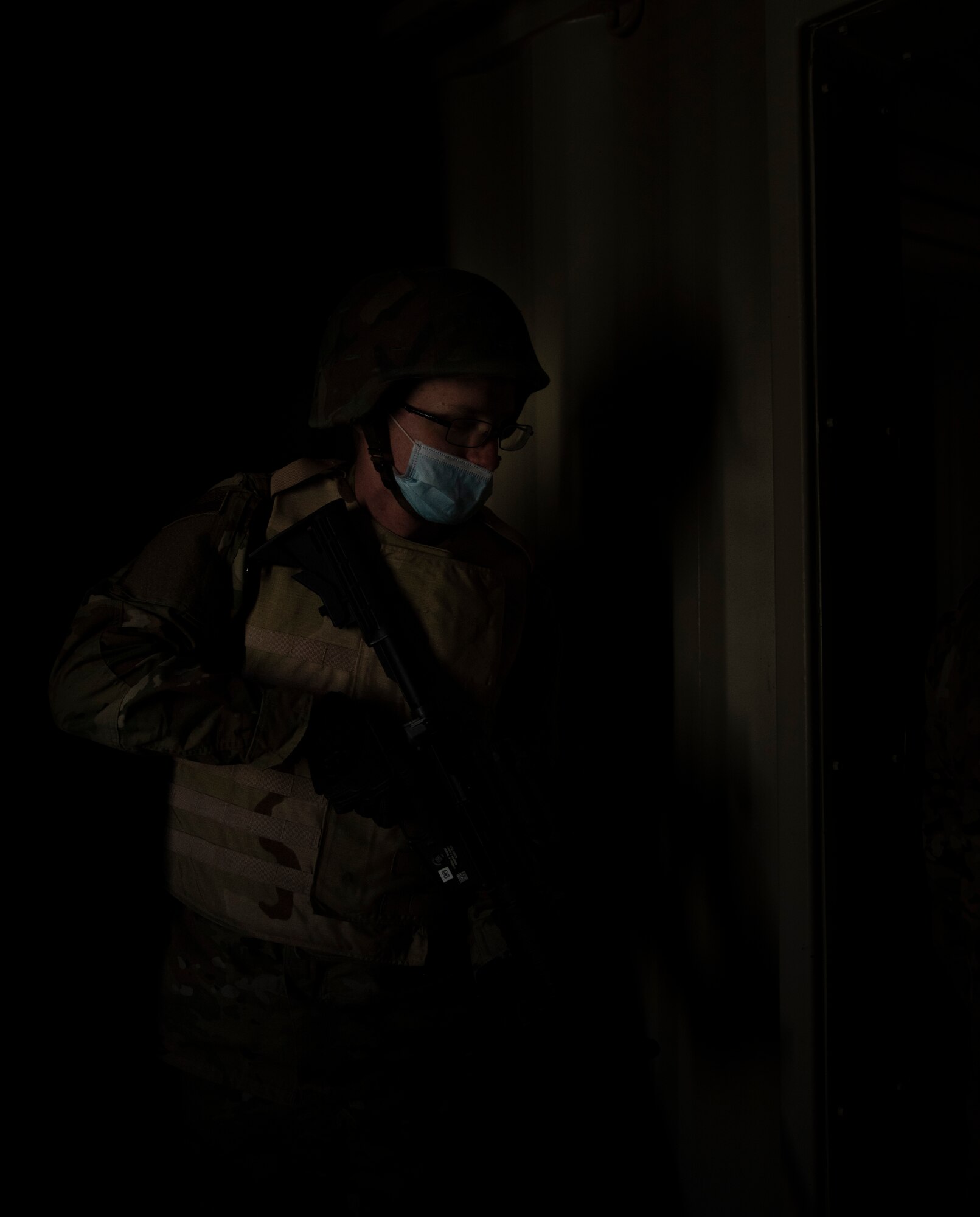 A male Airman stands ready to clear a room during tactical training.