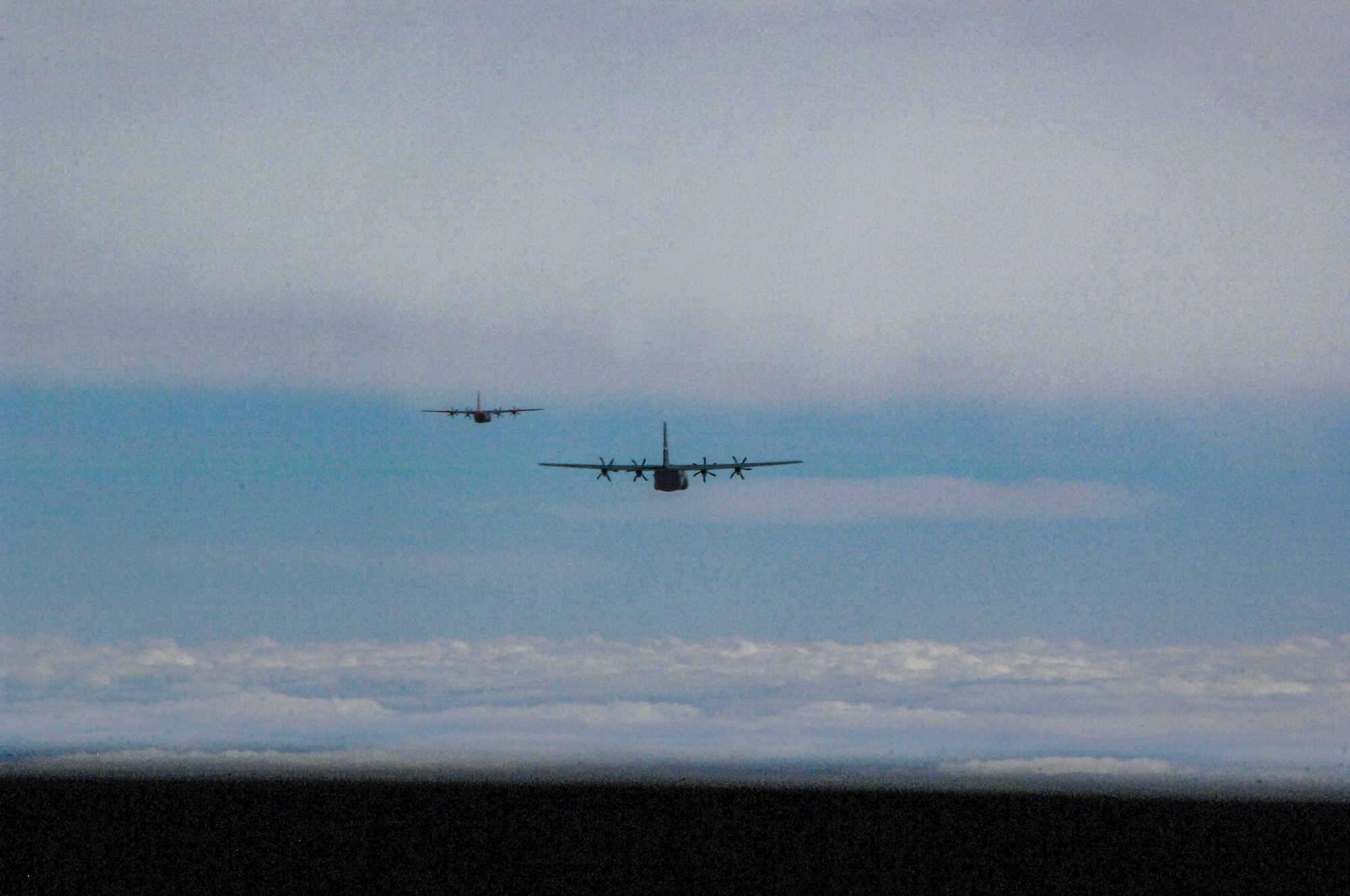 Two C-130s fly in formation