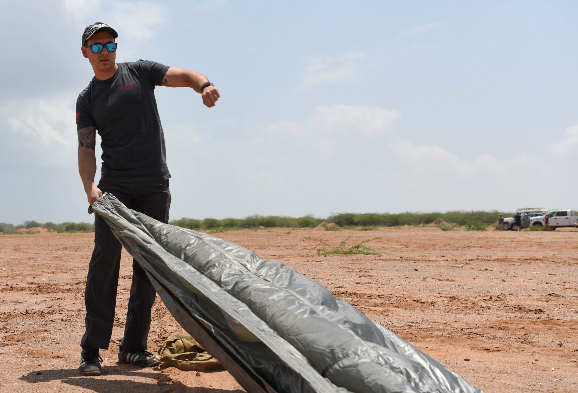 A U.S. Air Force pararescueman assigned to the 82nd Expeditionary Rescue Squadron prepares to fold a parachute after a jump at Camp Lemonnier, Djibouti, March 16, 2021.