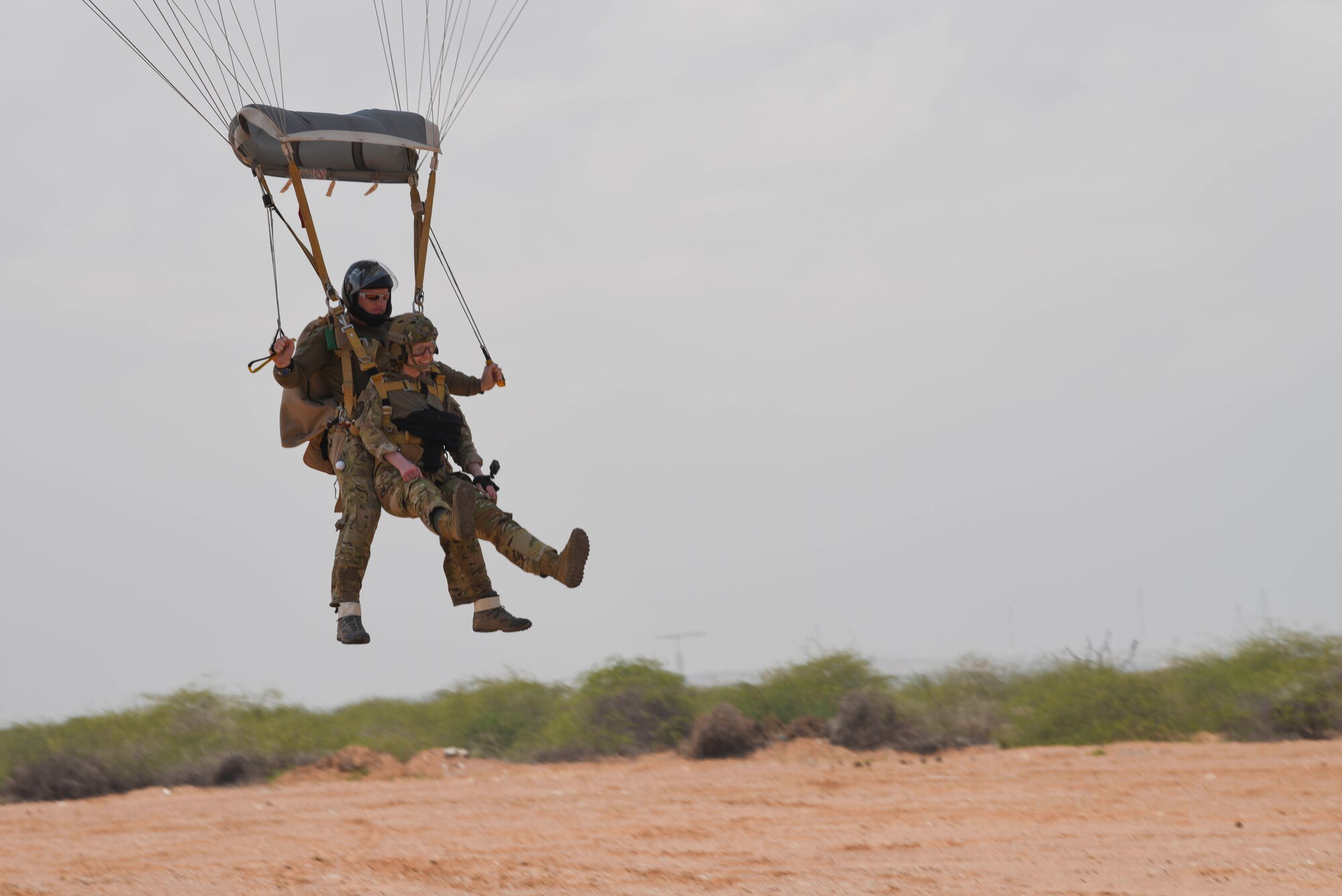 A U.S. Air Force pararescueman assigned to the 82nd Expeditionary Rescue Squadron, prepares to land after a tandem jump at Camp Lemonnier, Djibouti, March 16, 2021.