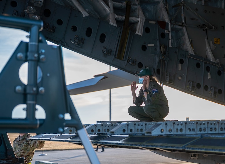 Sgt. Madison Cave-Freeman, Royal Australian Air Force 36th Squadron loadmaster, marshals a K-loader to the ramp of a RAAF C-17 Globemaster III at Dover Air Force Base, Delaware, March 13, 2021. The U.S. and Australia maintain a robust relationship underpinned by shared democratic values, common interests and cultural bonds. The U.S.-Australia alliance is an anchor for peace and stability in the Indo-Pacific region and around the world. (U.S. Air Force photo by Airman 1st Class Faith Schaefer)