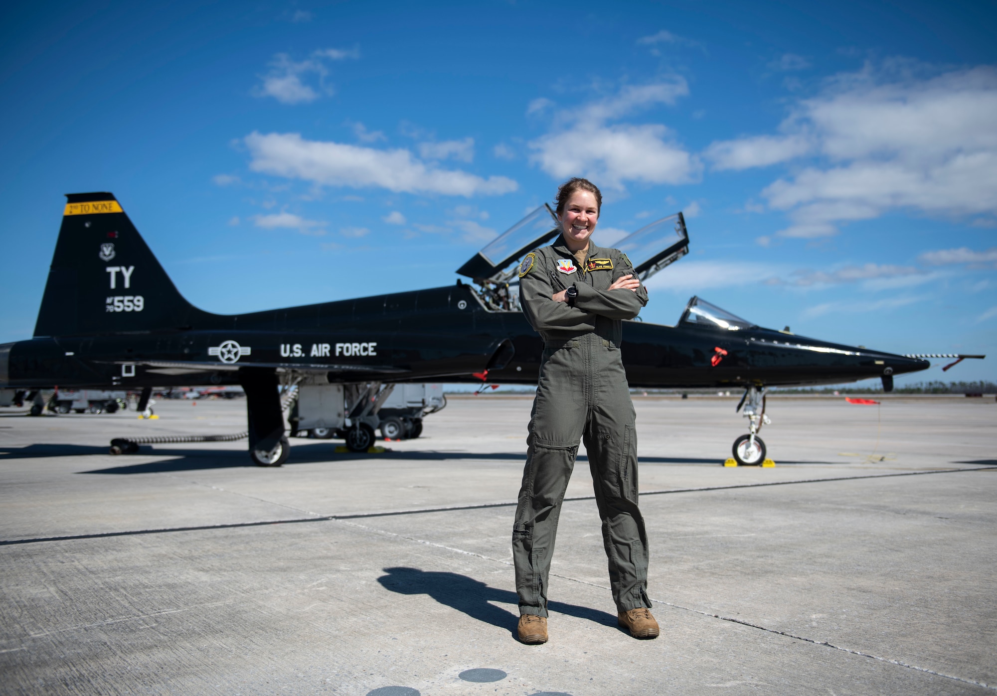 Woman poses in front of an airplane