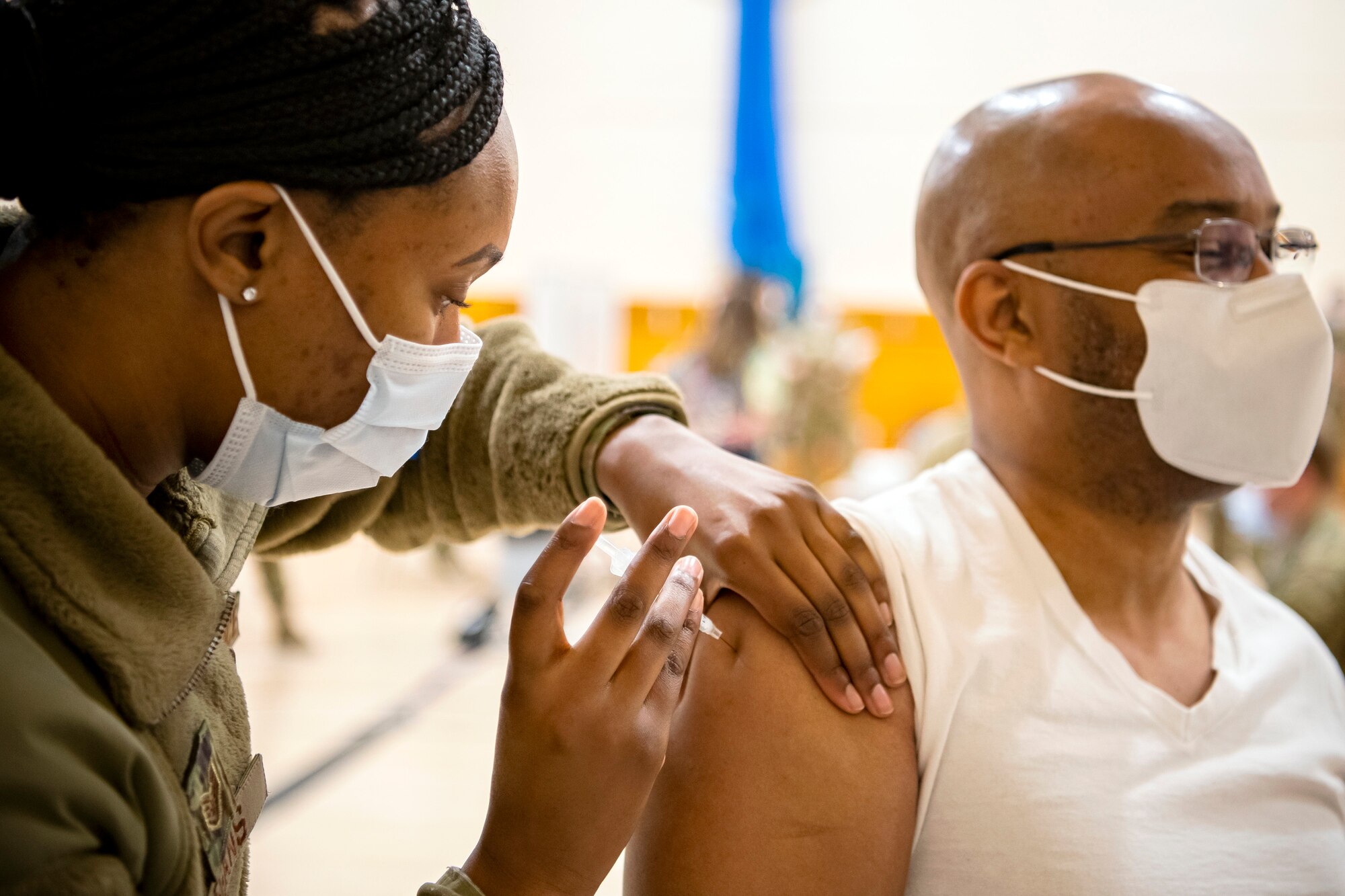 Staff Sgt. Danielle Regans, left, 423rd Medical Squadron medical technician, administers the COVID-19 vaccine during a mass vaccination line at RAF Alconbury, England, Mar. 18, 2021. This is the first time the 501st CSW has conducted a mass-vaccination line and are expected to vaccinate approximately 300 people. Multiple Airmen and civilians from the 423rd Medical, Civil Engineering, Emergency management and Communication squadrons assisted in helping vaccines be distributed to the pathfinder community. (U.S. Air Force photo by Senior Airman Eugene Oliver)
