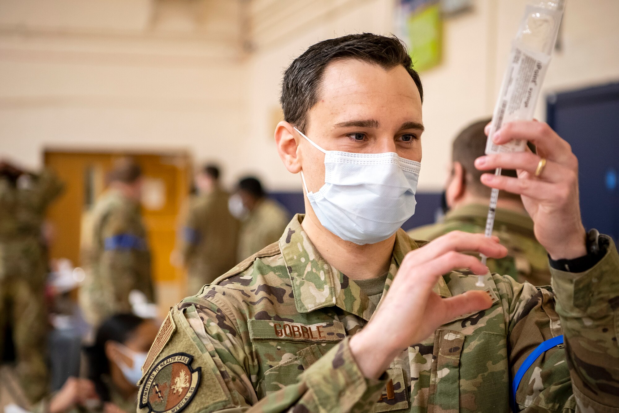 Capt. Joel Gobble, 423rd Medical Squadron general dentist, prepares to administer the COVID-19 vaccine during a mass vaccination line at RAF Alconbury, England, Mar. 18, 2021. This is the first time the 501st CSW has conducted a mass-vaccination line and are expected to vaccinate approximately 300 people. Multiple Airmen and civilians from the 423rd Medical, Civil Engineering, Emergency management and Communication squadrons assisted in helping vaccines be distributed to the pathfinder community. (U.S. Air Force photo by Senior Airman Eugene Oliver)