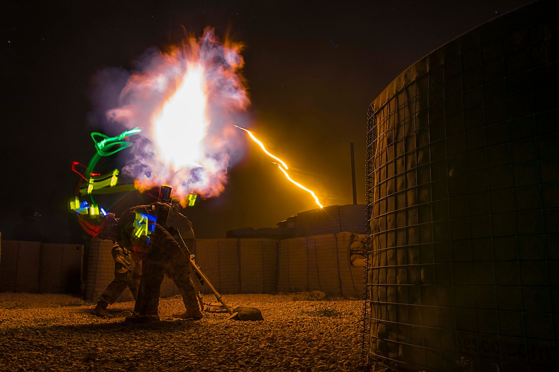 Solider fire illumination rounds in the dark illuminated by colorful lights.