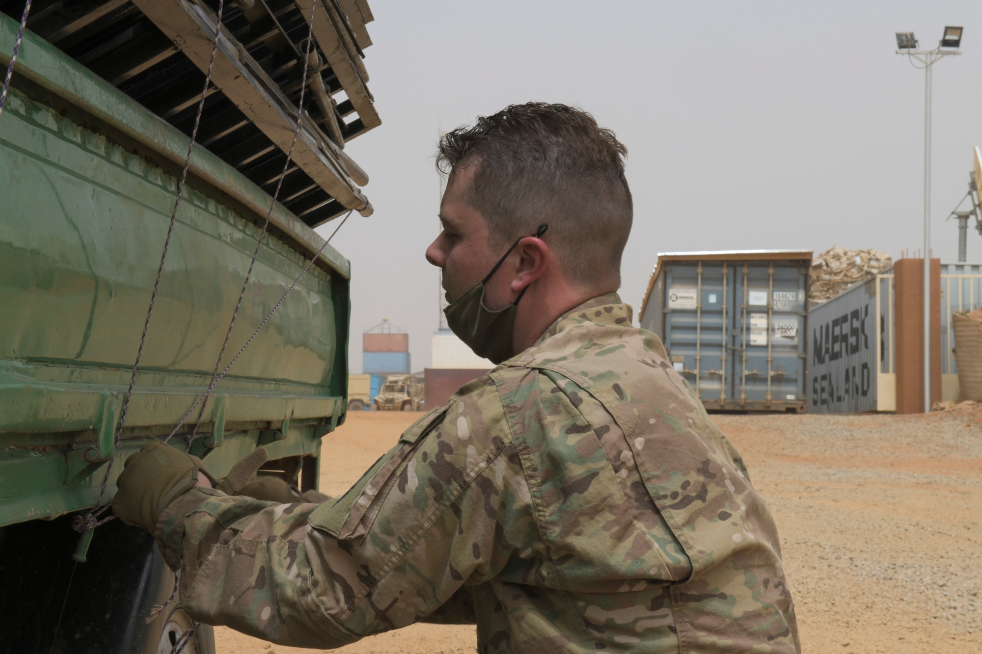 U.S. Air Force Staff Sgt. Casey Barron, 768th Expeditionary Air Base Squadron postmaster, ensures the broken bed frames are secure to the back of a pickup truck at Nigerien Air Base 101, Niamey, Niger, Feb. 17, 2021. Bunk beds are replacing cots to better the quality of life for transient members coming to Air Base 101. (U.S. Air Force photo by Senior Airman Gabrielle Winn)