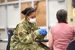 Michigan Air National Guard Staff Sgt. Ayanna McFaddin, 127th Medical Group, 127th Wing, Selfridge Air National Guard Base, administers the coronavirus vaccine during a district-wide event for school employees at Niles High School, Niles, Michigan, March 12, 2021. The Guard and state health officials have been working with local health departments to make sure vaccines are available throughout the state.