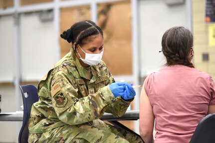 Michigan Air National Guard Staff Sgt. Ayanna McFaddin, 127th Medical Group, 127th Wing, Selfridge Air National Guard Base, administers the coronavirus vaccine during a district-wide event for school employees at Niles High School, Niles, Michigan, March 12, 2021. The Guard and state health officials have been working with local health departments to make sure vaccines are available throughout the state.