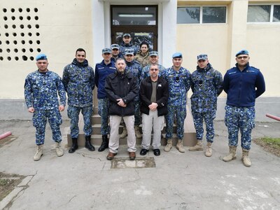Photo of Tobyhanna Army Depot Training Instructors Gregory Wirth (left) and Vincent Zuranski (right) pose with students during a recent mission to train Romanian Air Force personnel.