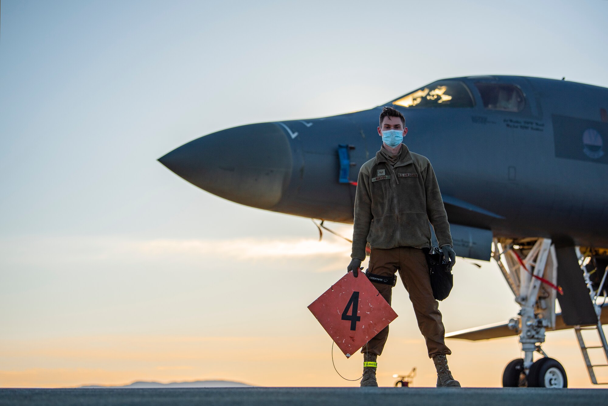 A weapons load crew team chief assigned to the 9th Expeditionary Bomb Squadron stands in front of a B-1B Lancer at Ørland Air Force Station, Norway, March 13, 2021. Four weapons load crew members loaded bomber dummy units into a B-1B Lancer prior to a Bomber Task Force Europe training mission. (U.S. Air Force photo by Airman 1st Class Colin Hollowell)