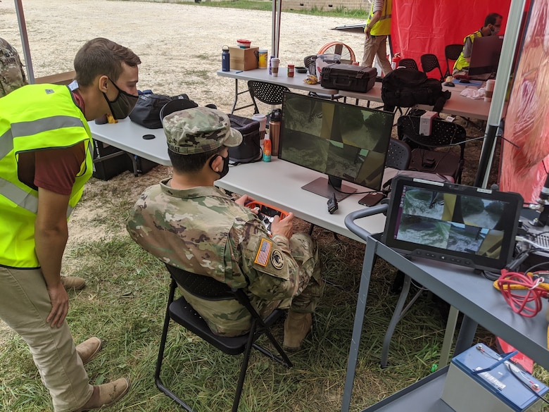 A U.S. Army officer utilizes a remote-control station to operate an 8-ton excavator from beyond visual line of sight at a distance of approximately 200 m during the Maneuver Support, Sustainment, Protection Integration Experiment (MSSPIX20) demonstration at Fort Leonard Wood, Missouri, Sept. 16, 2020. The U.S. Army Engineer Research and Development Center researchers demonstrated unmanned capabilities for combat engineers during the MSSPIX20 training exercise. (U.S. Army Corps of Engineers photo)