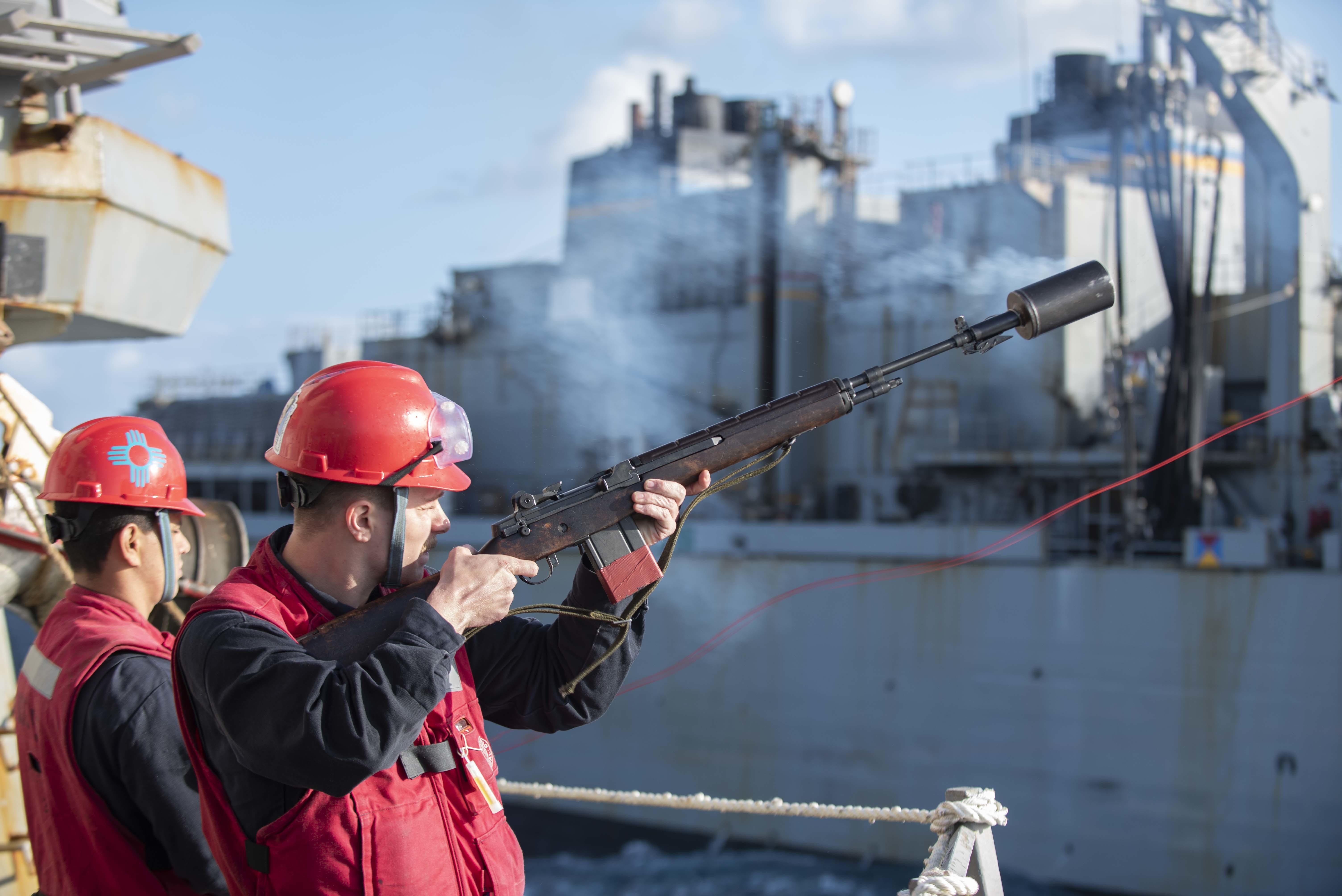 Gunner's Mate 2nd Class Wesley Malavenda, from Chesapeake, Ohio, fires a shot line to the Supply-class fast combat supply support ship USNS Arctic (T-AOE 8) during a replenishment-at-sea .