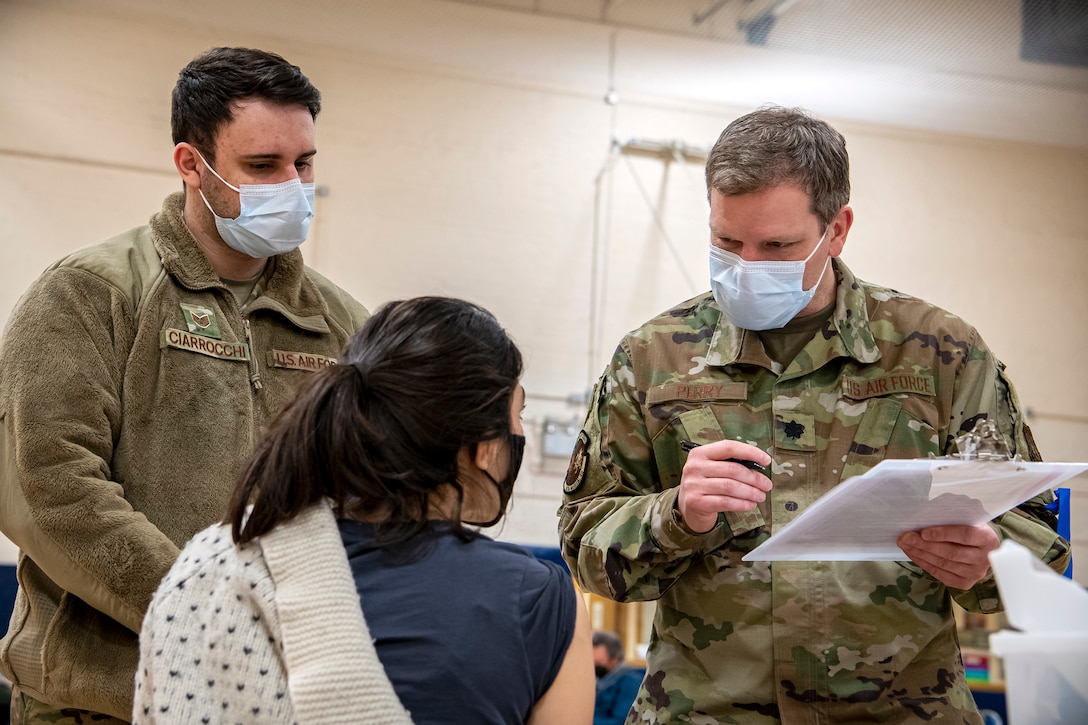 Lt. Col. Zachary Perry, 423rd Medical Squadron, chief of dental services, speaks with a patient during a mass COVID-19 vaccination line at RAF Alconbury, England, Mar. 18, 2021. This is the first time the 501st CSW has conducted a mass-vaccination line and are expected to vaccinate approximately 300 people. Multiple Airmen and civilians from the 423rd Medical, Civil Engineering, Emergency management and Communication squadrons assisted in helping vaccines be distributed to the pathfinder community. (U.S. Air Force photo by Senior Airman Eugene Oliver)