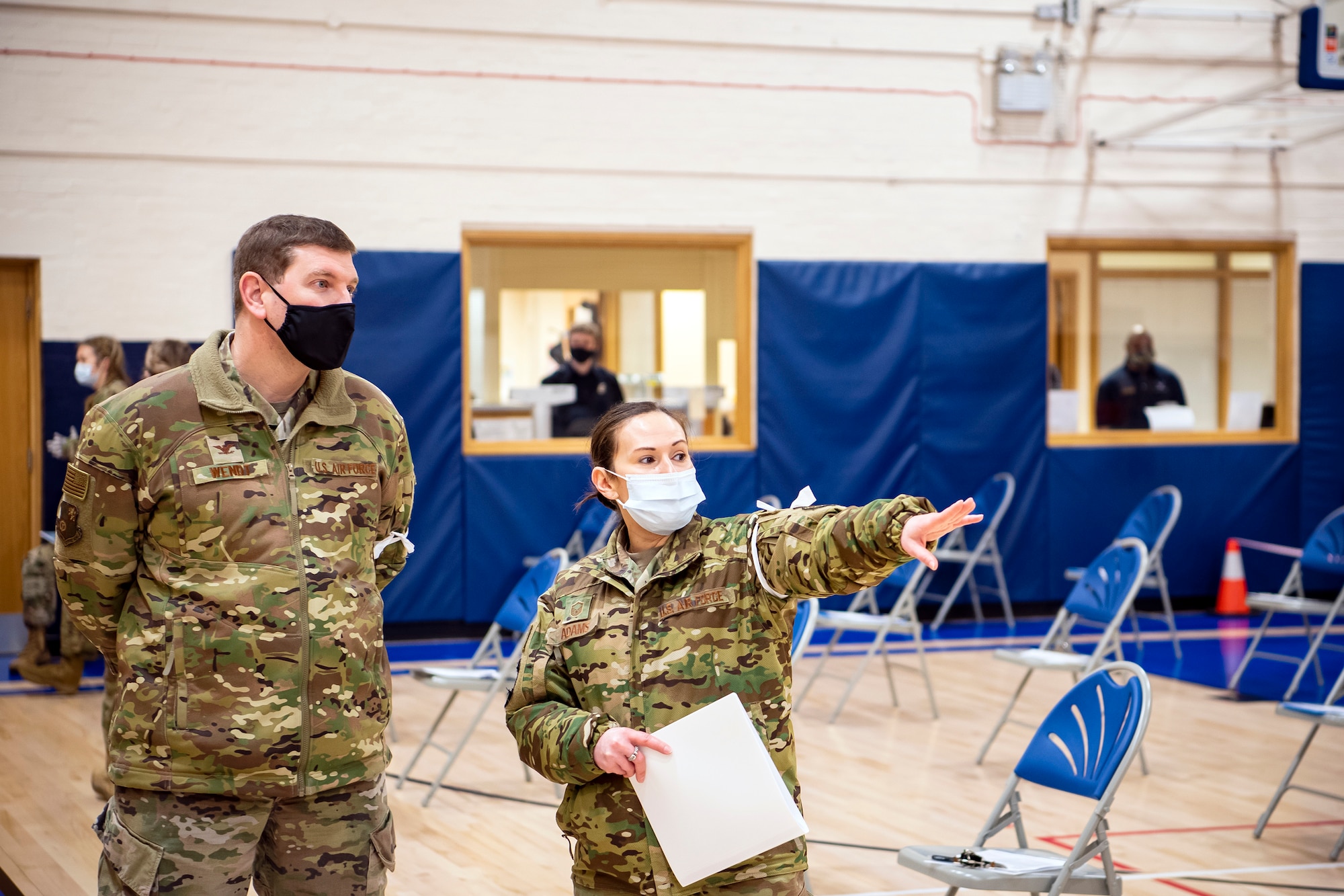Master Sgt. Terri Adams, right, 423rd Civil Engineering squadron NCO in charge of Emergency management, speaks with Col. Kurt Wendt, 501st Combat Support Wing commander during a mass COVID-19 vaccination line at RAF Alconbury, England, Mar. 18, 2021. This is the first time the 501st CSW has conducted a mass-vaccination line and are expected to vaccinate approximately 300 people. Adams along with multiple Airmen and civilians from the 423rd Medical, Civil Engineering, Emergency management and Communication squadrons assisted in helping vaccines be distributed to the pathfinder community. (U.S. Air Force photo by Senior Airman Eugene Oliver)