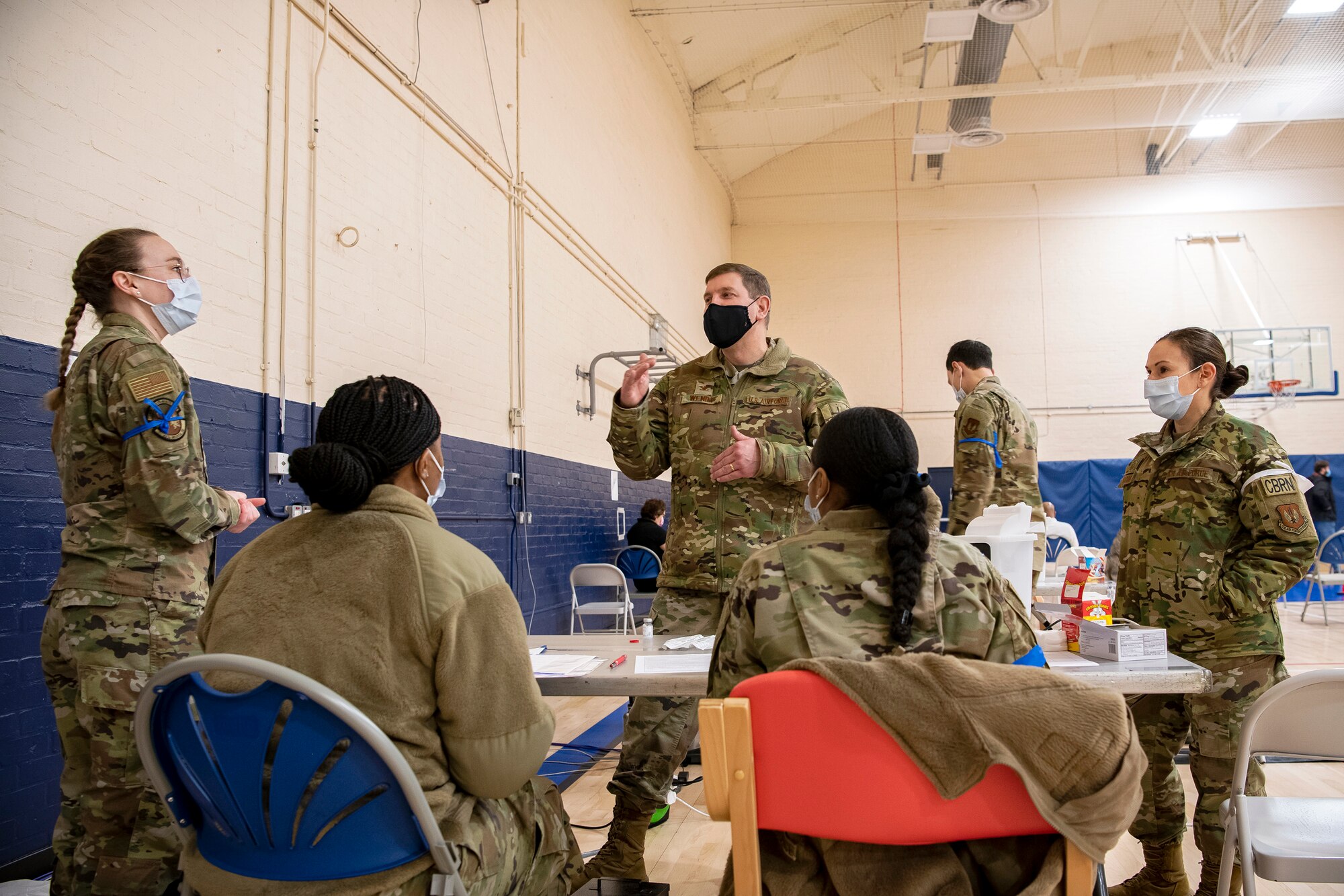 Col. Kurt Wendt, 501st Combat Support Wing commander, speaks with Airmen from the 501st CSW during a mass COVID-19 vaccination line at RAF Alconbury, England, Mar. 18, 2021. This is the first time the 501st CSW has conducted a mass-vaccination line and are expected to vaccinate approximately 300 people. Multiple Airmen and civilians from the 423rd Medical, Civil Engineering, Emergency management and Communication squadrons assisted in helping vaccines be distributed to the pathfinder community. (U.S. Air Force photo by Senior Airman Eugene Oliver)