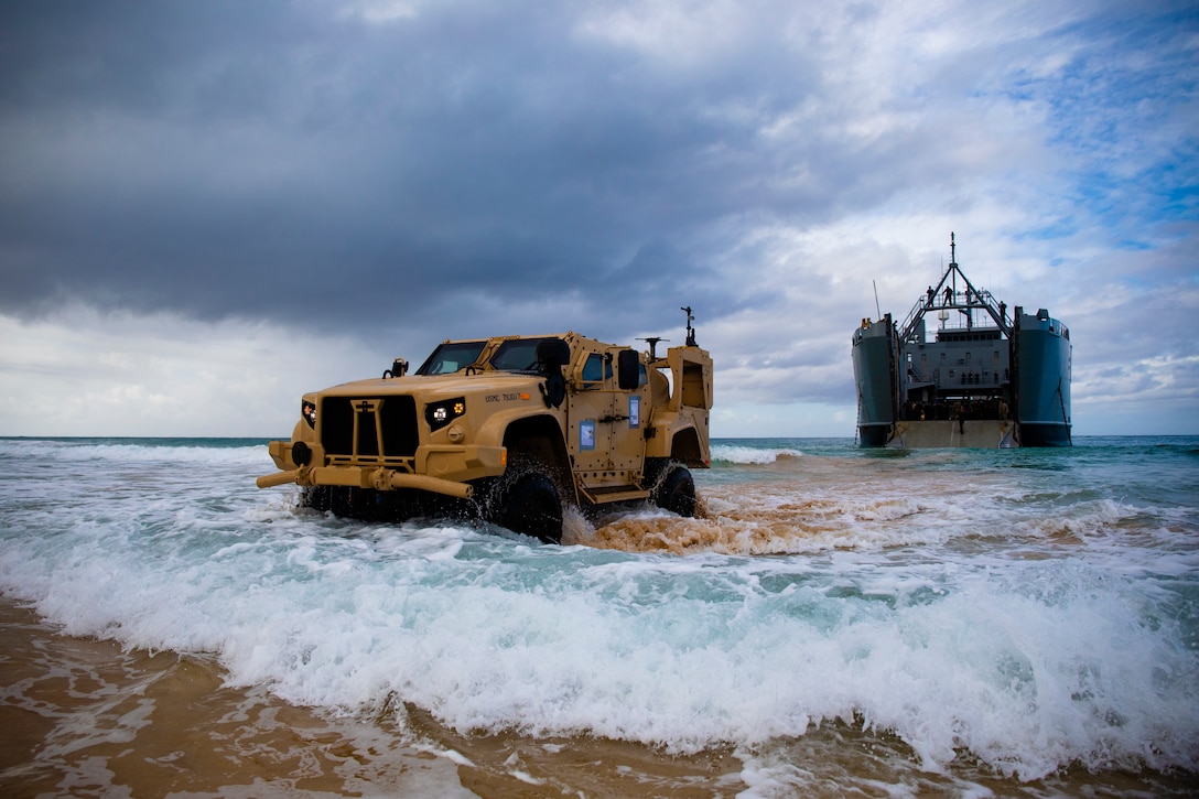 U.S. Marines with 1st Battalion, 12th Marines, unload a joint light tactical vehicle from a U.S. Army logistics support vessel attached to 8th Special Troops Battalion, 8th Theater Sustainment Command, during the Spartan Fury 21.1 training exercise, March 3, 2021, Major's Bay, Pacific Missile Range Facility, Kauai, Hawaii. Exercise Spartan Fury demonstrates 1/12's ability to conduct distributed operations inside an adversary's sensors and weapons engagement zone, attain and defend key maritime terrain, and conduct sea denial in support of fleet operations.