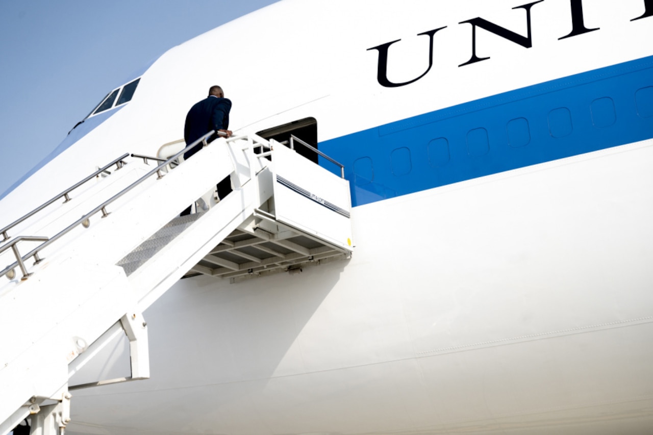 Man in business attire boards plane.