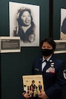 Air Force Master Sgt. Mary Jane Palumbo poses for a photo in front of a display honoring Maggie Gee in the Green Mountain Armory at Camp Johnson, Vermont, March 18, 2021. Palumbo, the aviation resource management superintendent for the Vermont Air National Guard's 158th Operations Group, was one of several Guardswomen who facilitated a book reading and showcase of Guard uniforms and equipment for a local day care center. (U.S. Army National Guard photo by Don Branum)